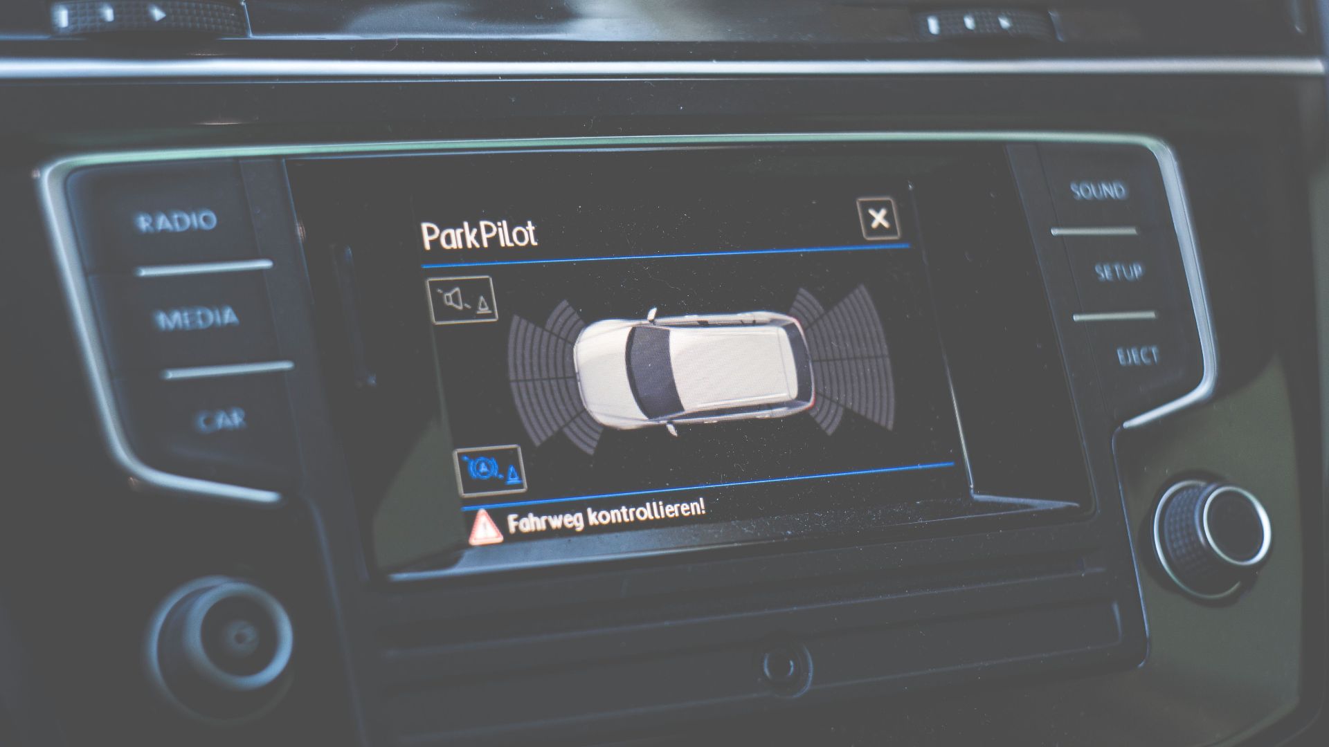 Close-up view of a car dashboard featuring a ParkPilot parking assist display.