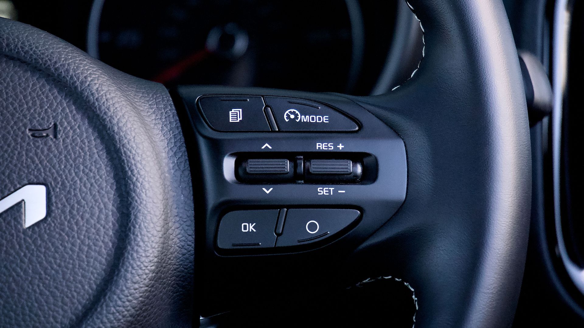 Detailed view of a car steering wheel with control buttons, showcasing modern design and functionality.
