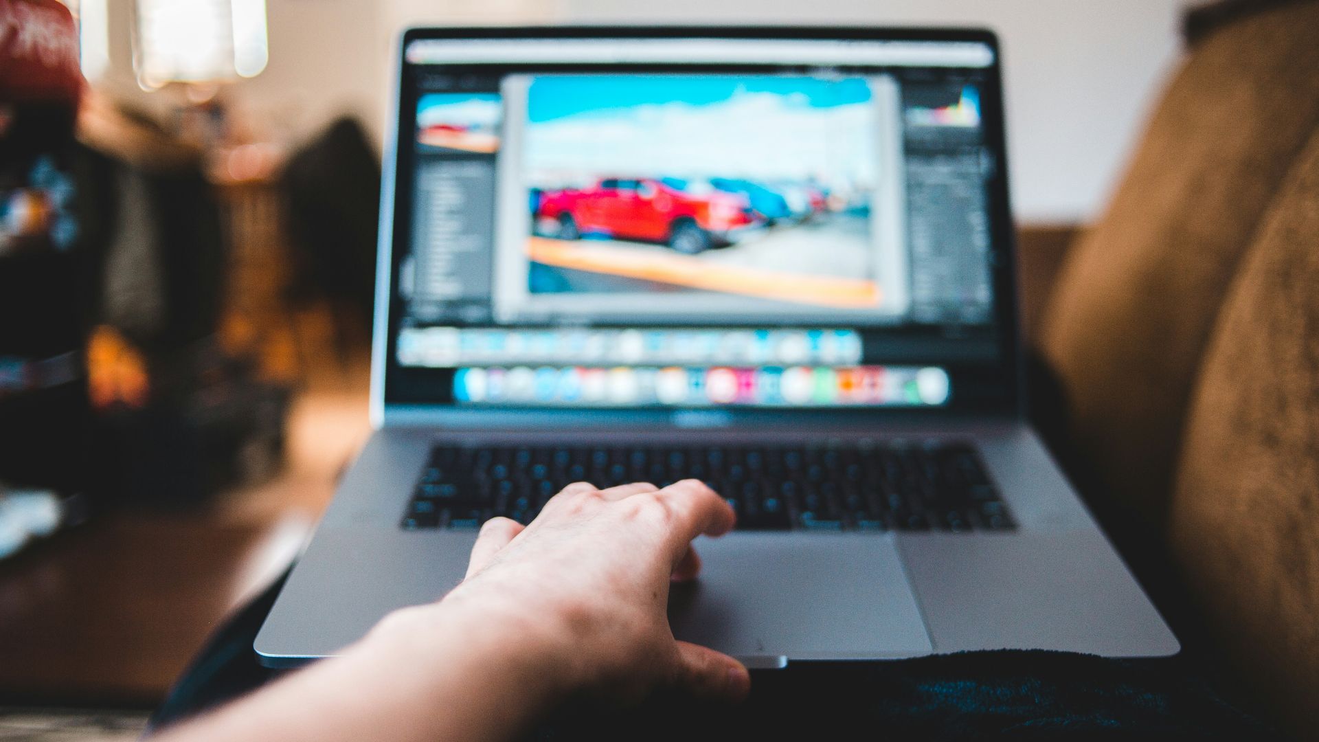 person using macbook pro on brown wooden table