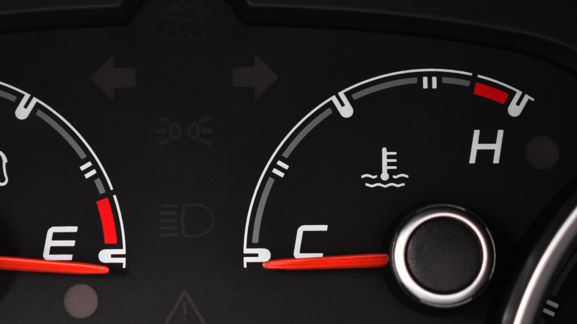 Detailed view of a car's fuel and temperature gauges on dashboard.