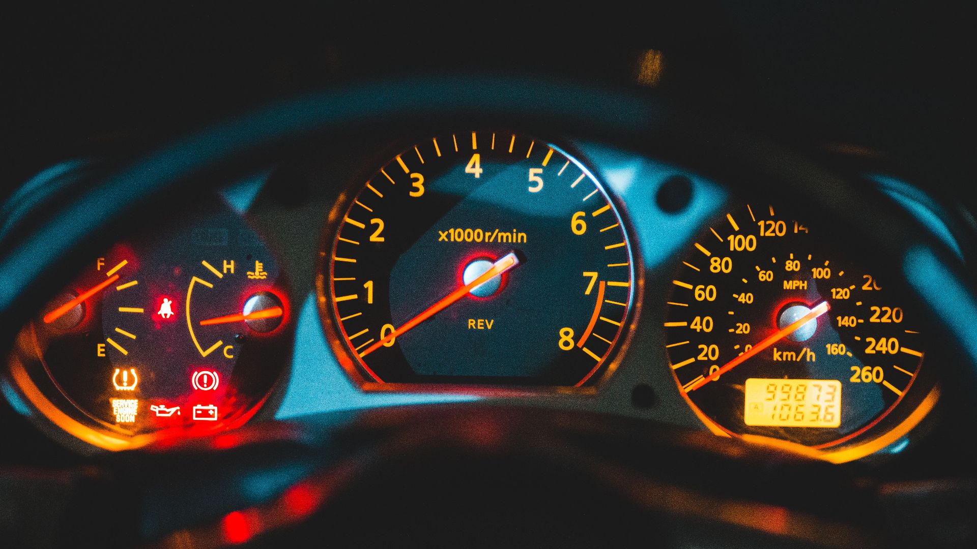 Closeup of tachometer near speedometer and oil pressure gauge on colorful dashboard in modern car