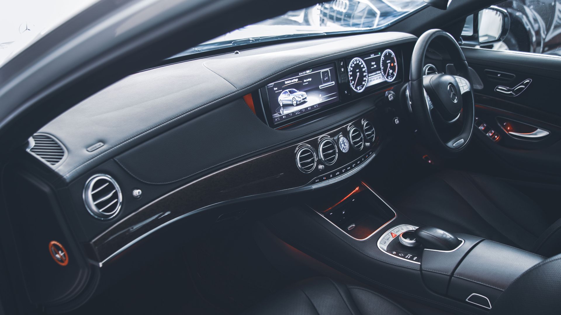 Sleek and modern luxury car interior showcasing leather seats and touchscreen dashboard.