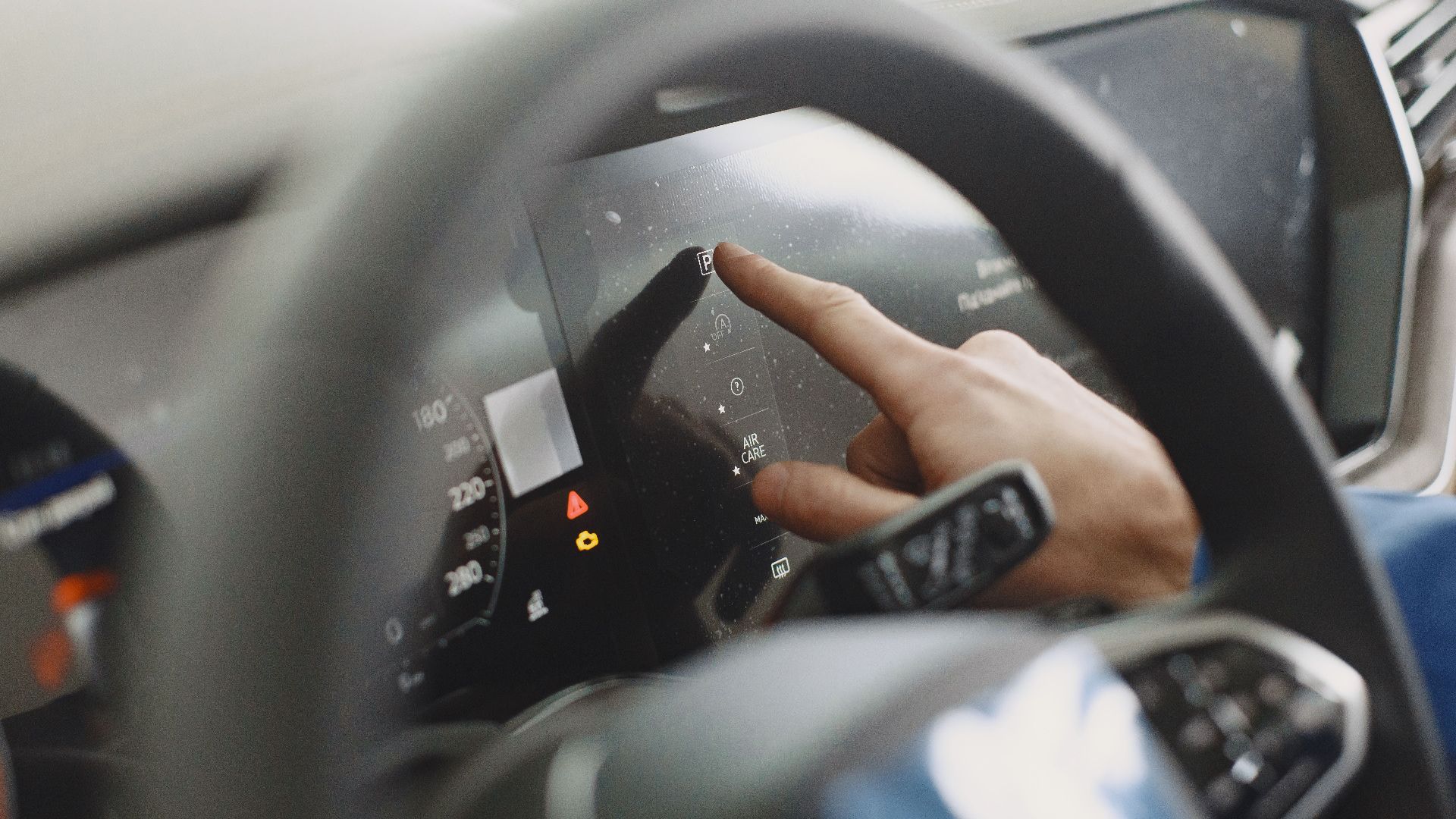 Close-up of a hand interacting with a car's digital dashboard. Modern technology and driving interface.