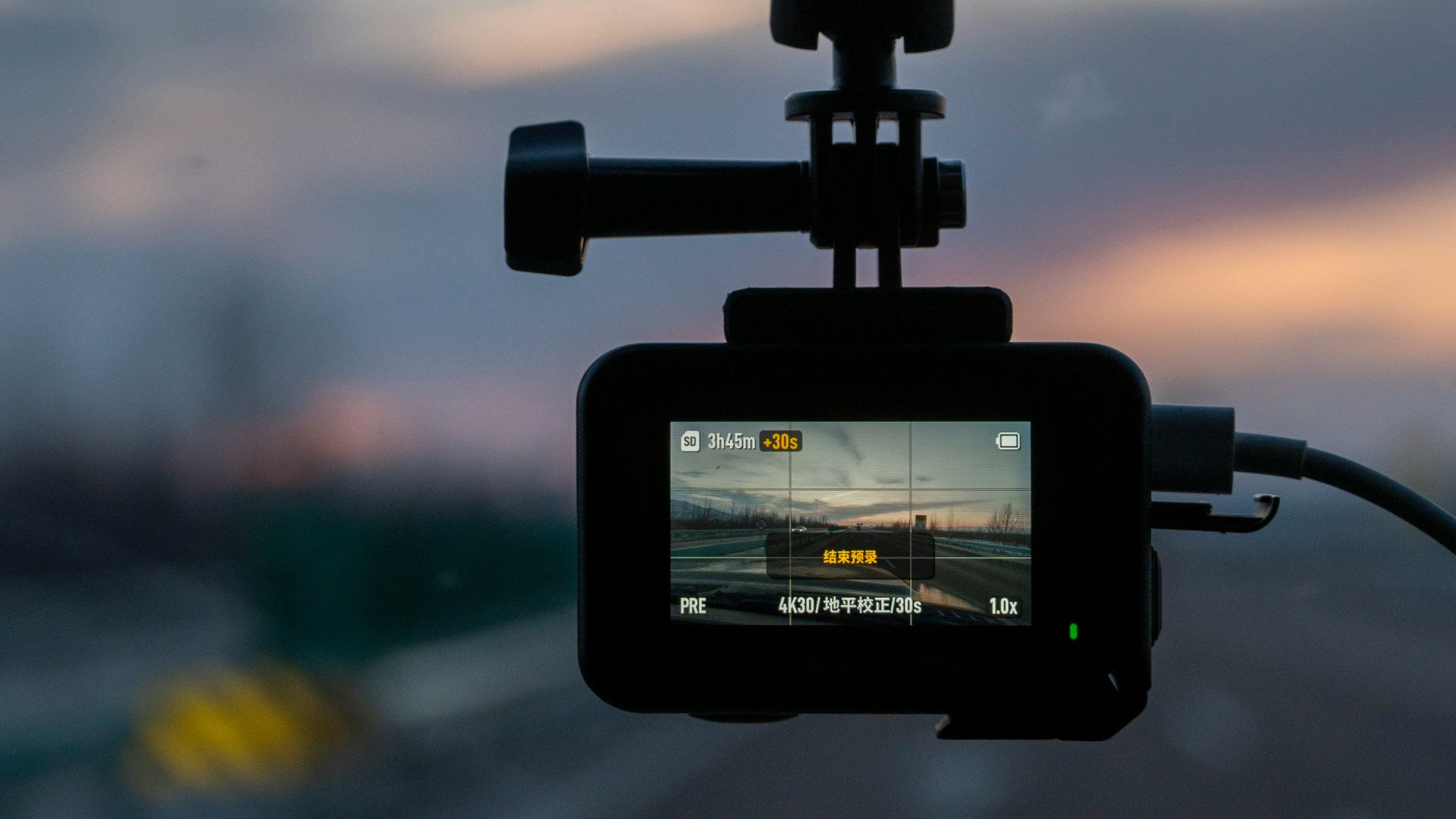 Action camera mounted on car windshield at sunset