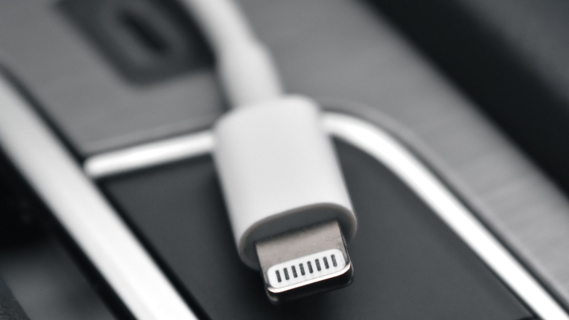 A detailed close-up image of a lightning connector against a sleek black surface, ideal for tech themes.