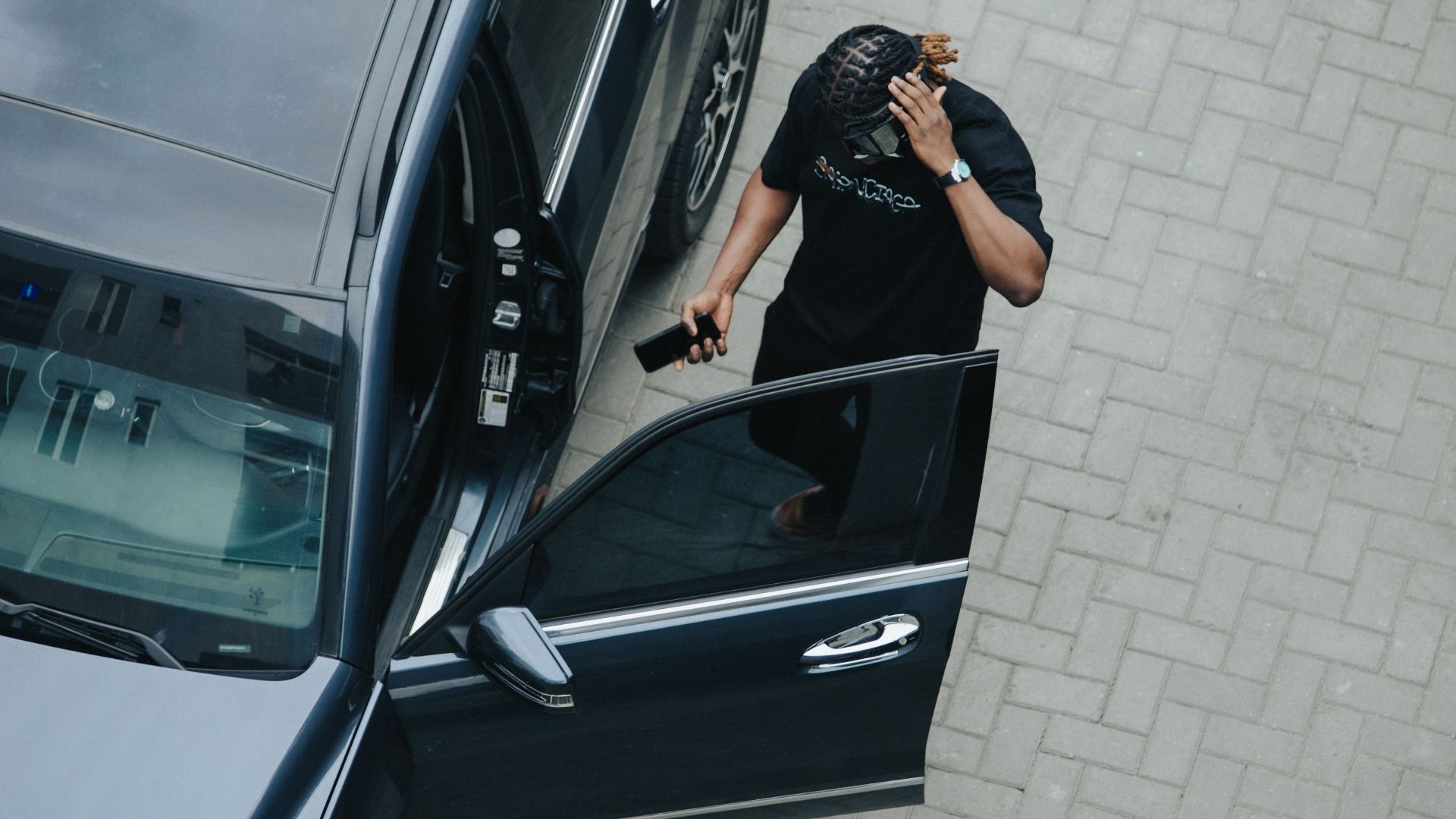 High angle view of a man standing near an open car door in Lagos, Nigeria.