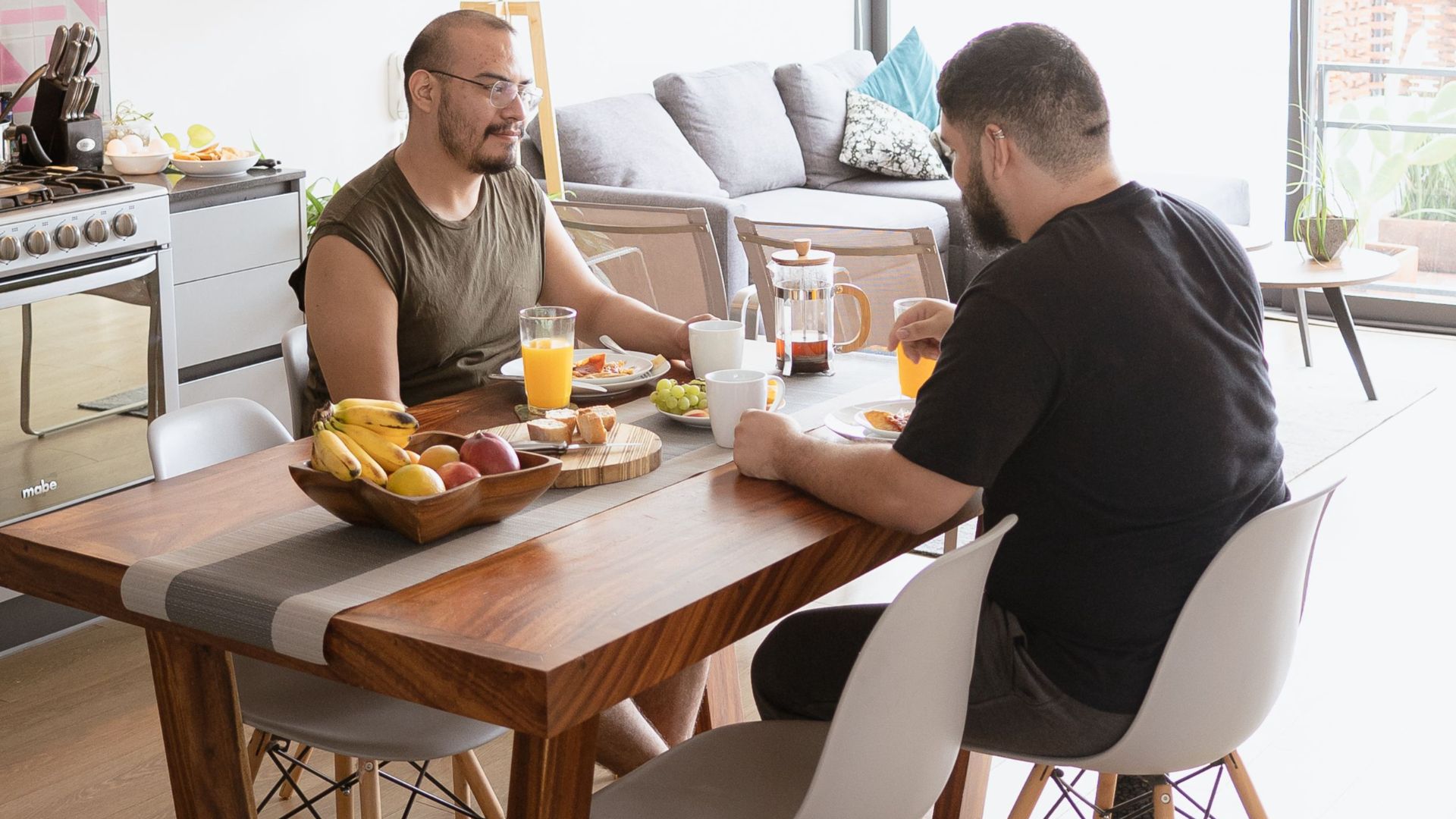 Two men enjoying a healthy breakfast at home, creating a warm and inviting atmosphere.