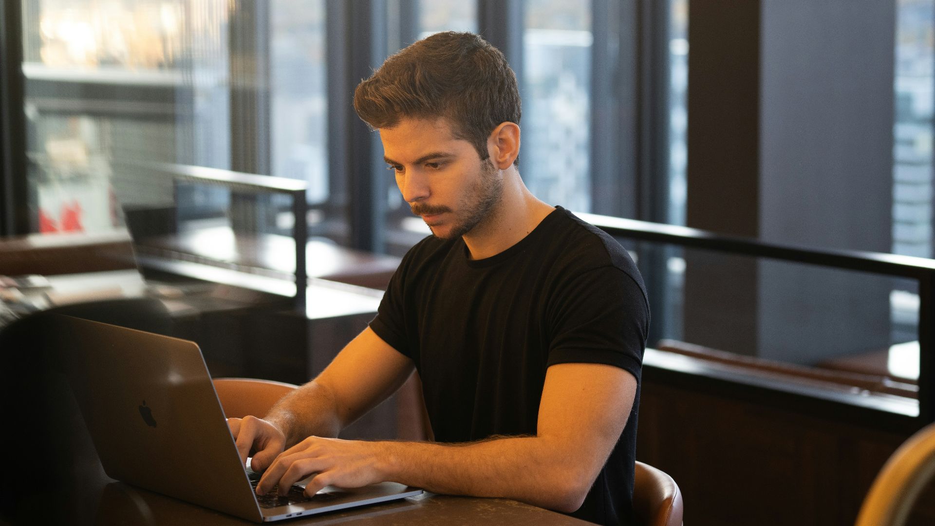 man in black crew neck t-shirt using macbook