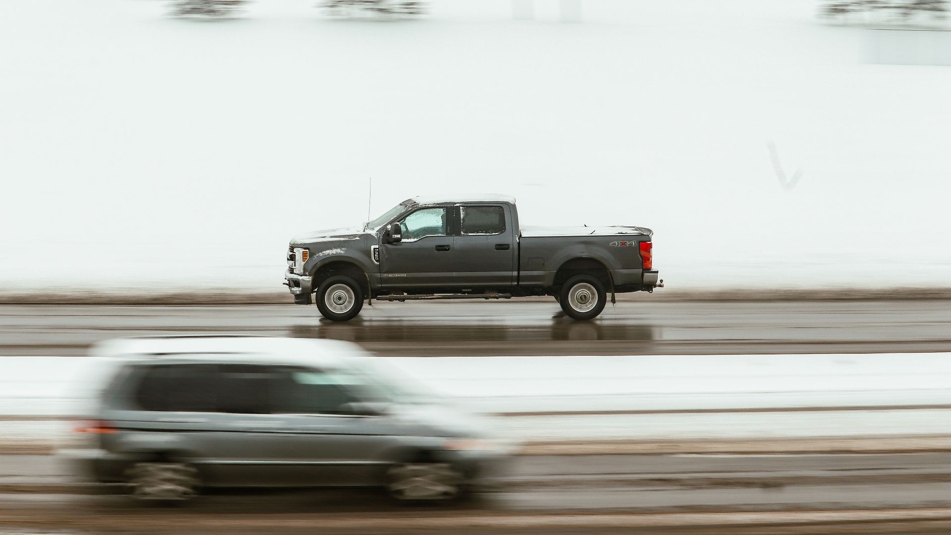 A pickup truck speeds through a snowy highway in Calgary, capturing motion and winter ambiance.