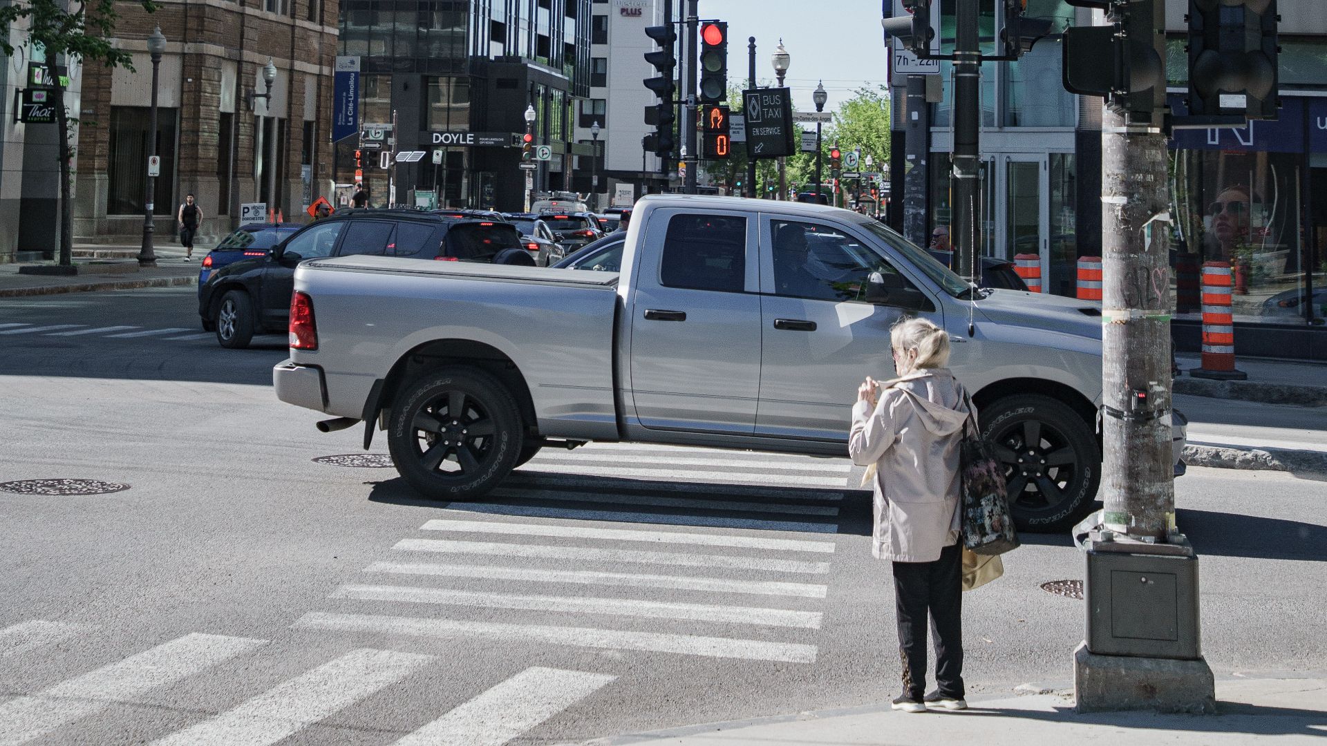 City street intersection featuring modern buildings and traffic in daylight.