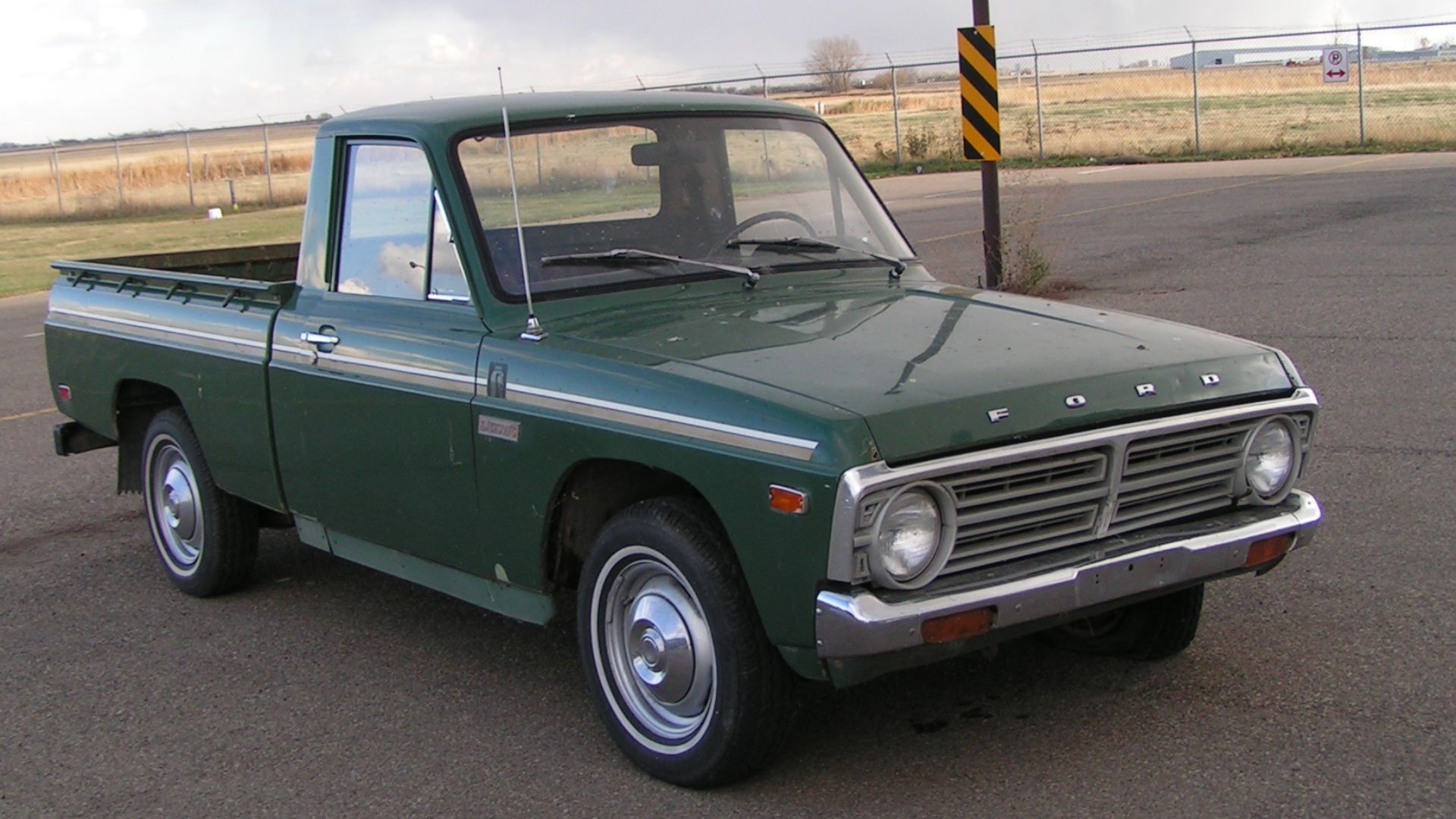 A green 1976 Ford Courier pickup truck.