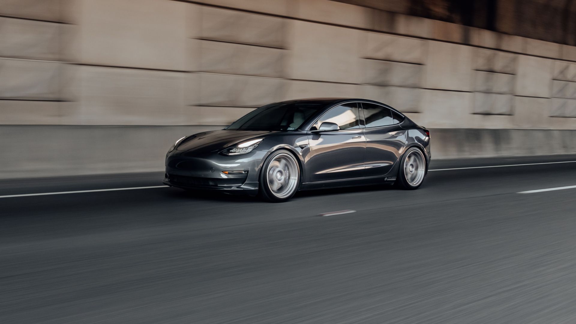 Dynamic view of a luxury electric car speeding on a highway, showcasing motion blur.