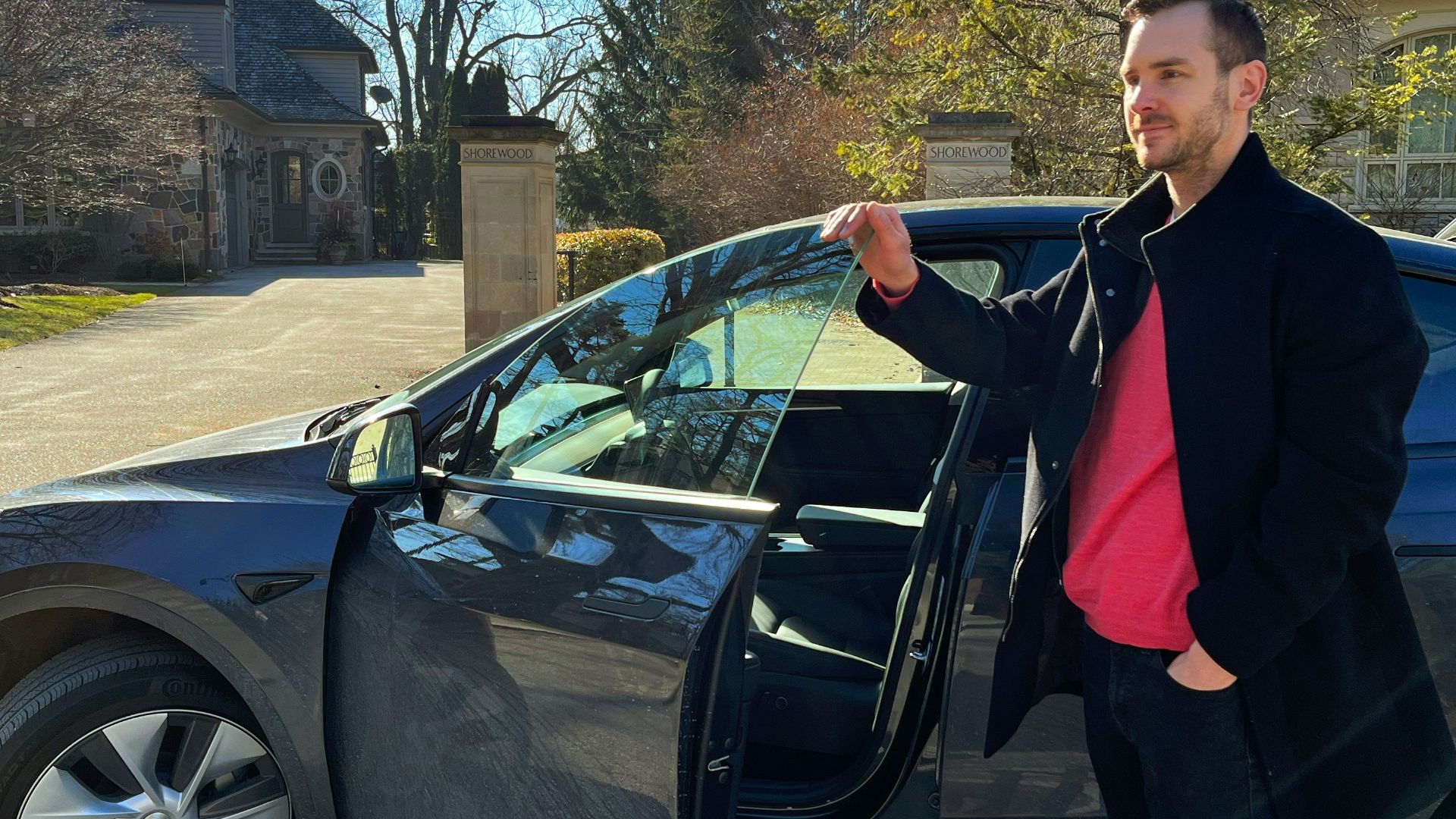 a man standing next to a car with its door open