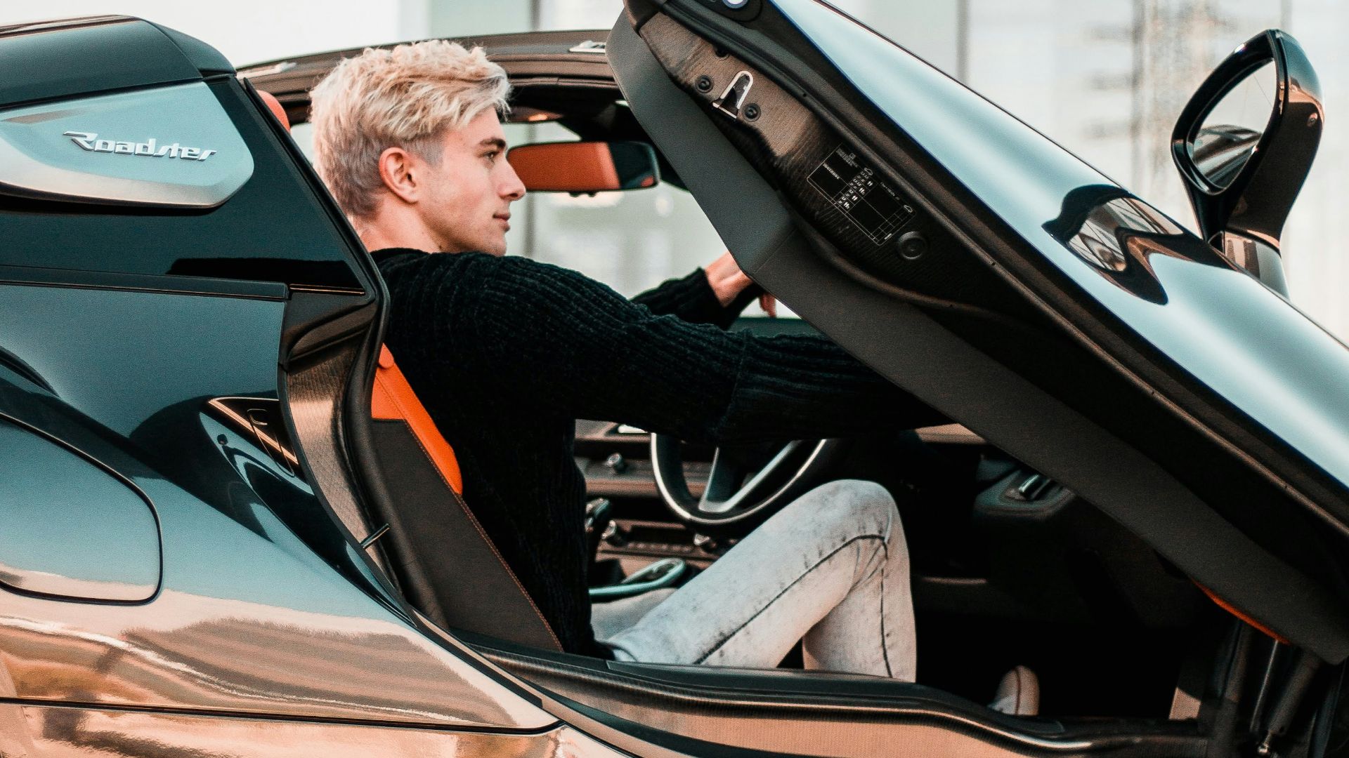 a man sitting inside of a futuristic car