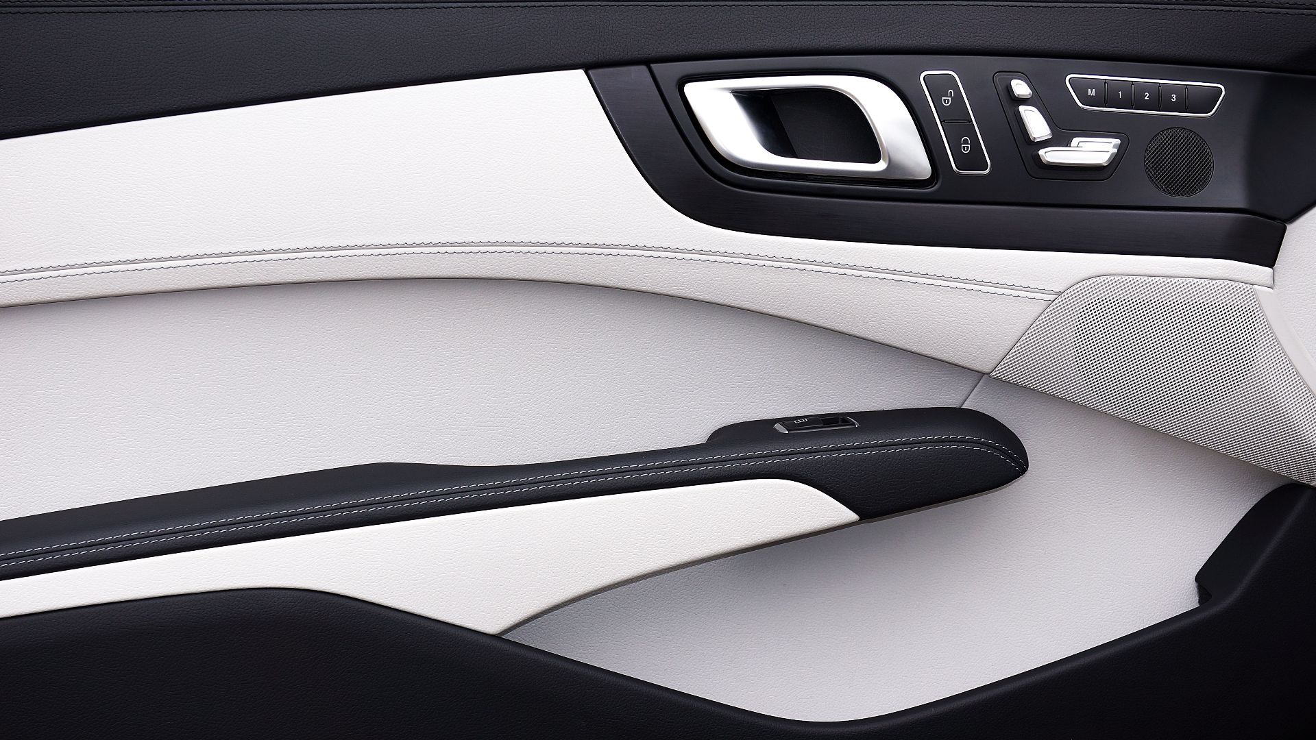 Close-up of a modern car door panel with a minimalist design and luxury materials.