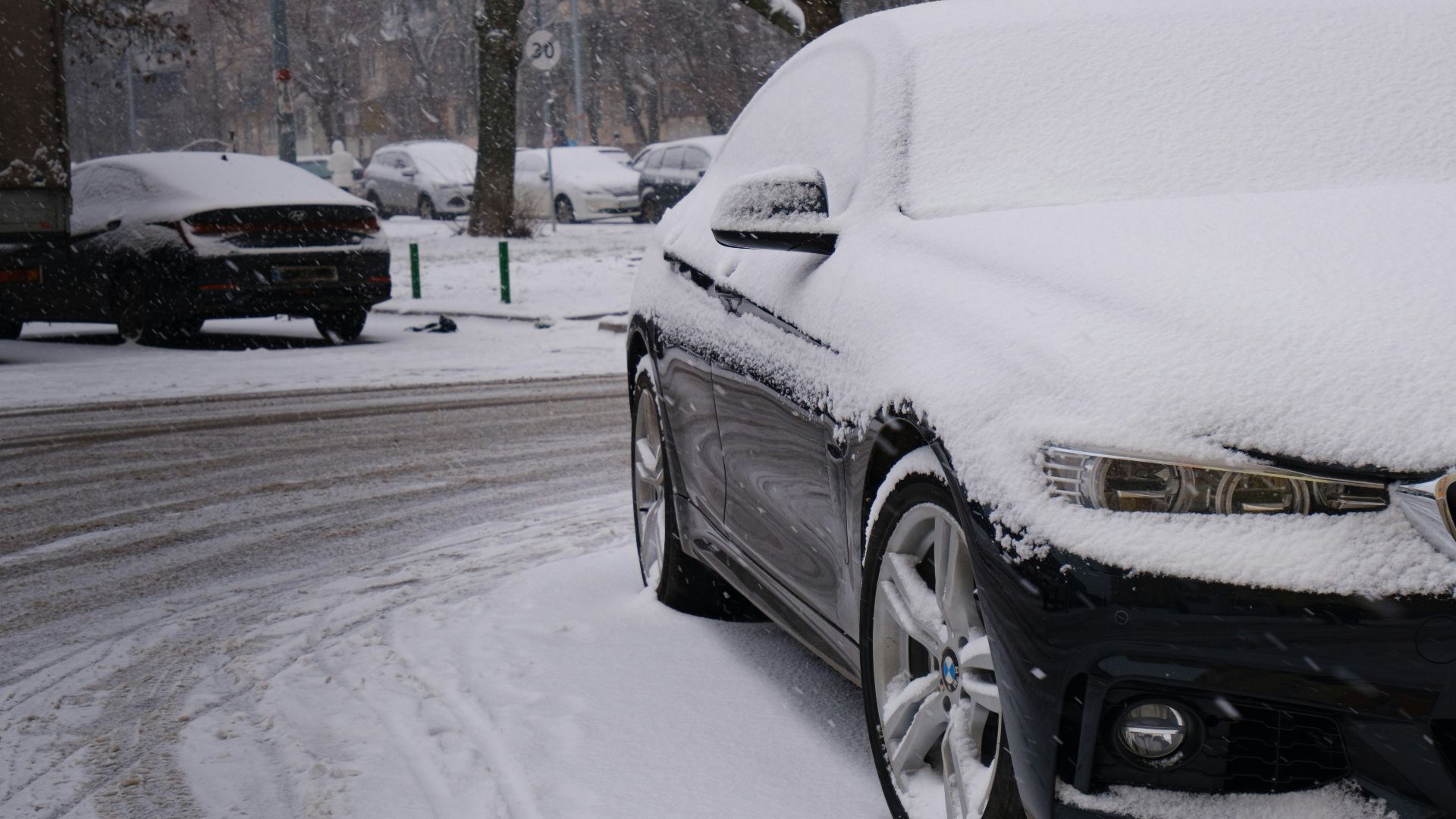 a car covered in snow on a snowy street