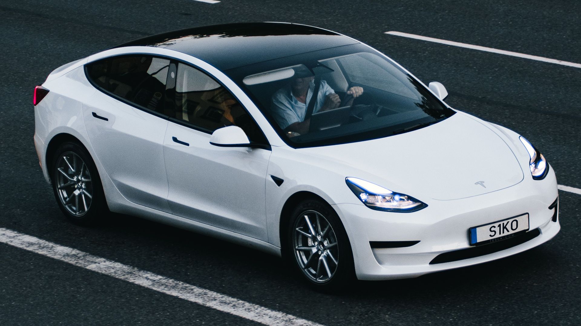 Tesla Model 3 driving on a highway in Osnabrück, Germany, showcasing modern electric vehicle design.