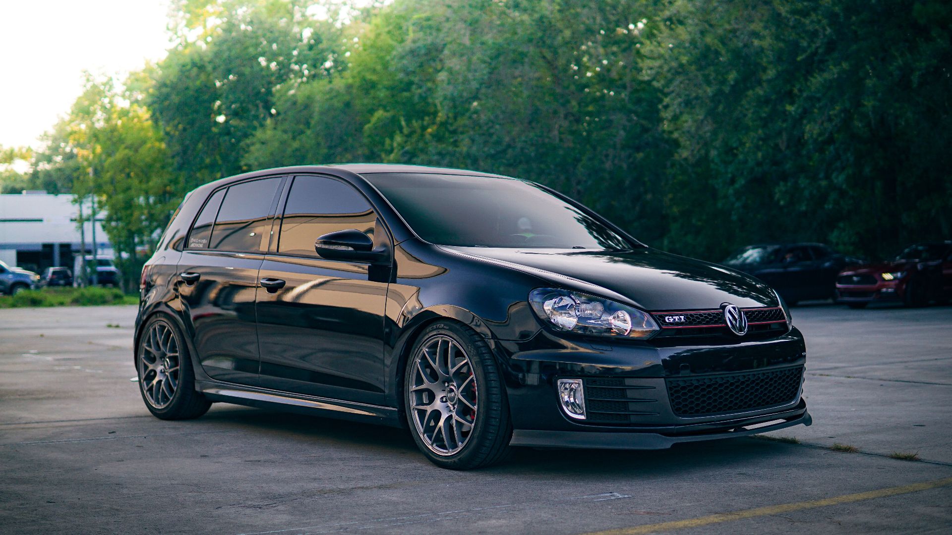 A custom-tuned Volkswagen Golf GTI parked outdoors, showcasing sports car elegance in an urban environment.