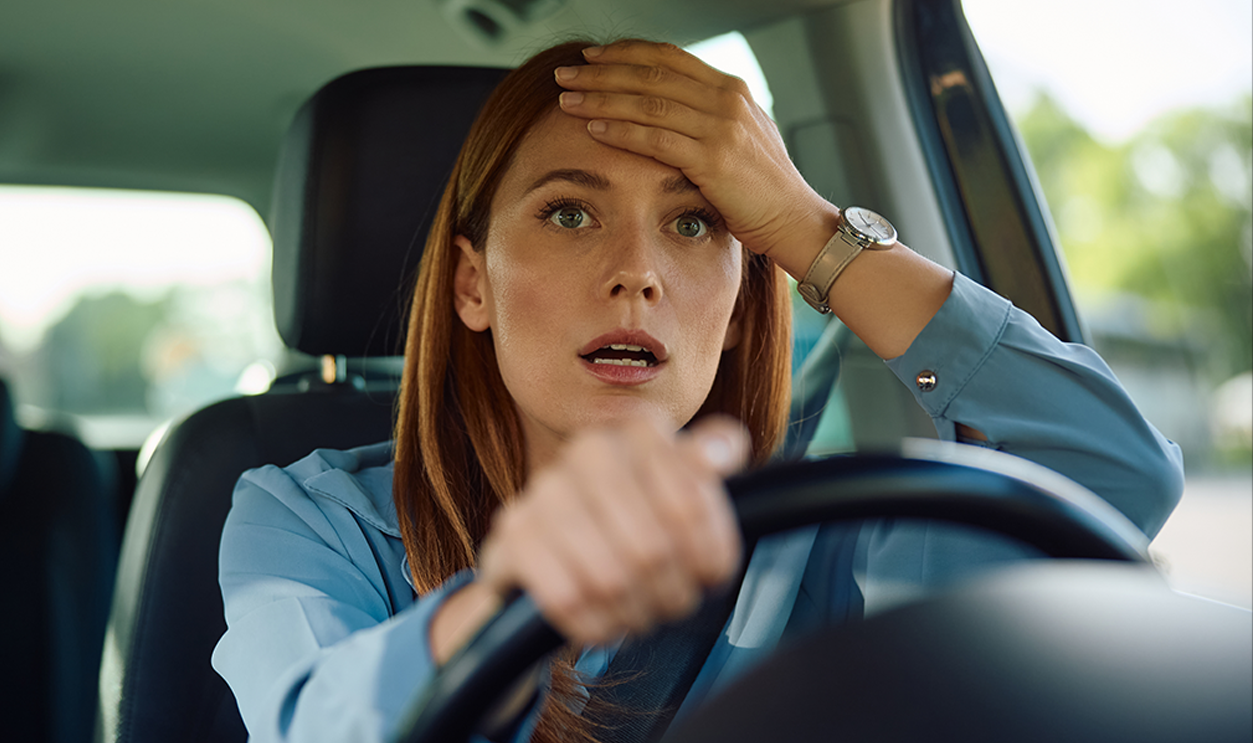 Shocked businesswoman driving a car