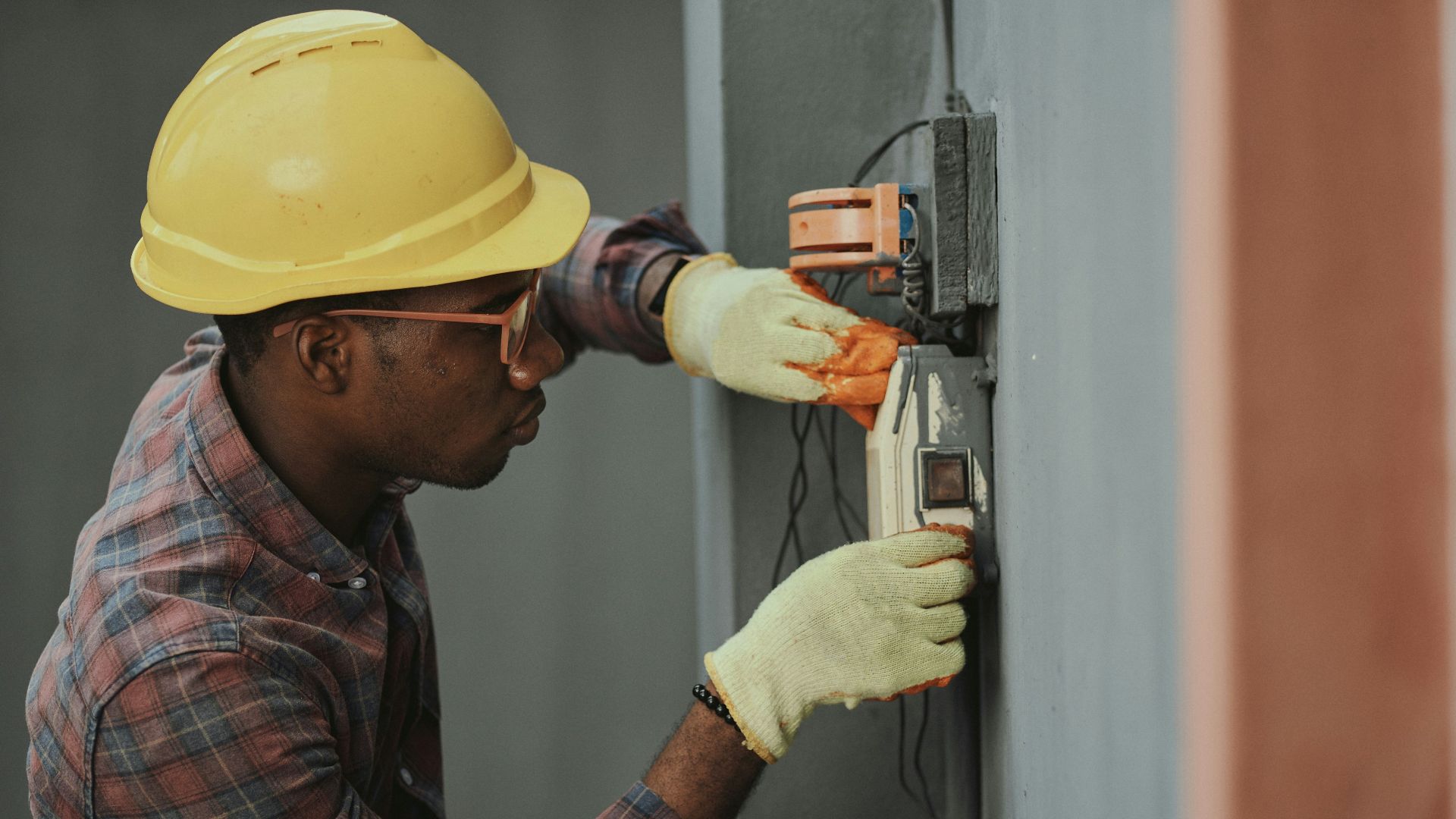 electrician installing wiring with yellow hardhat