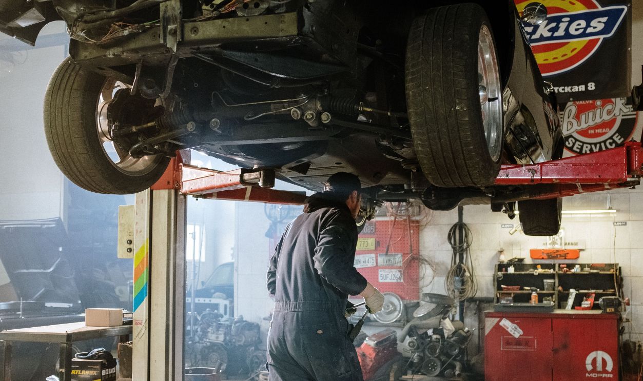 Mechanic repairing a vehicle in a busy workshop