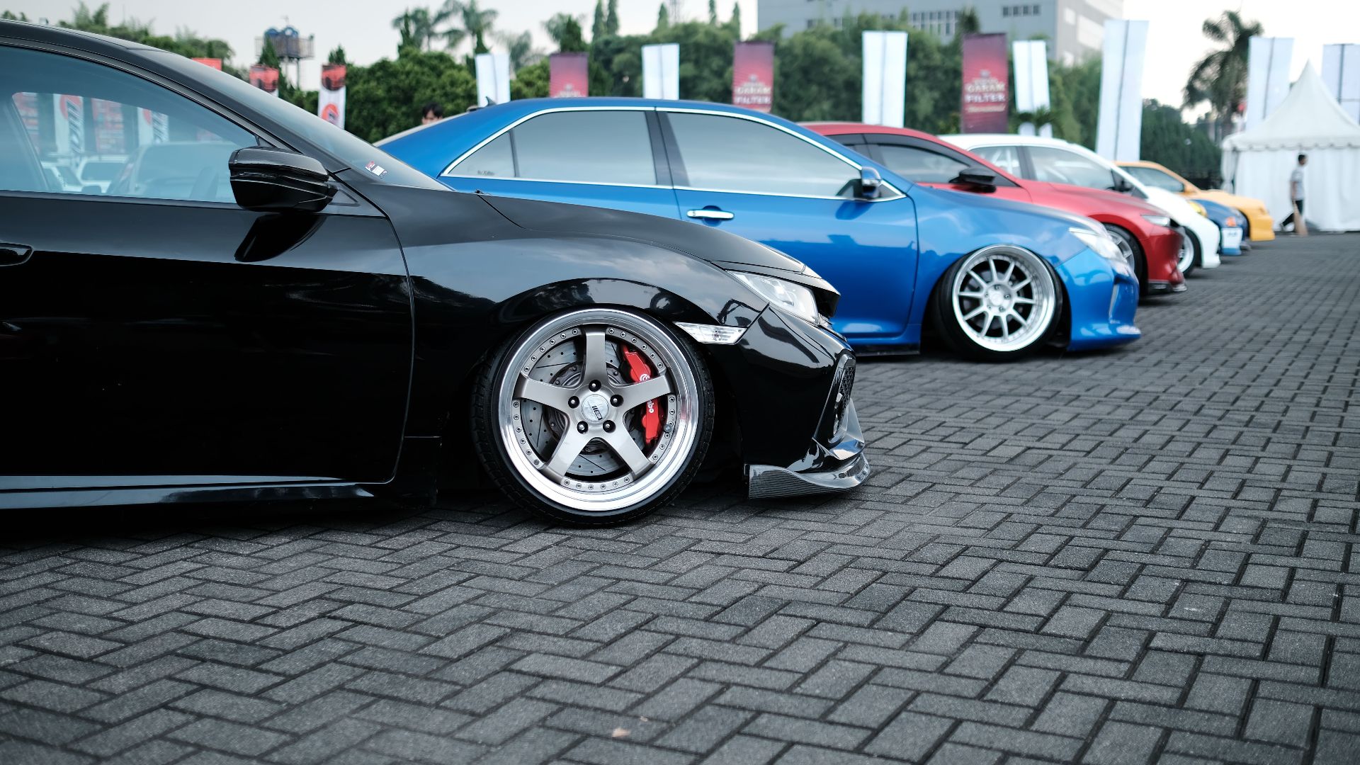 Showcase of sleek customized sports cars parked in an outdoor exhibition.