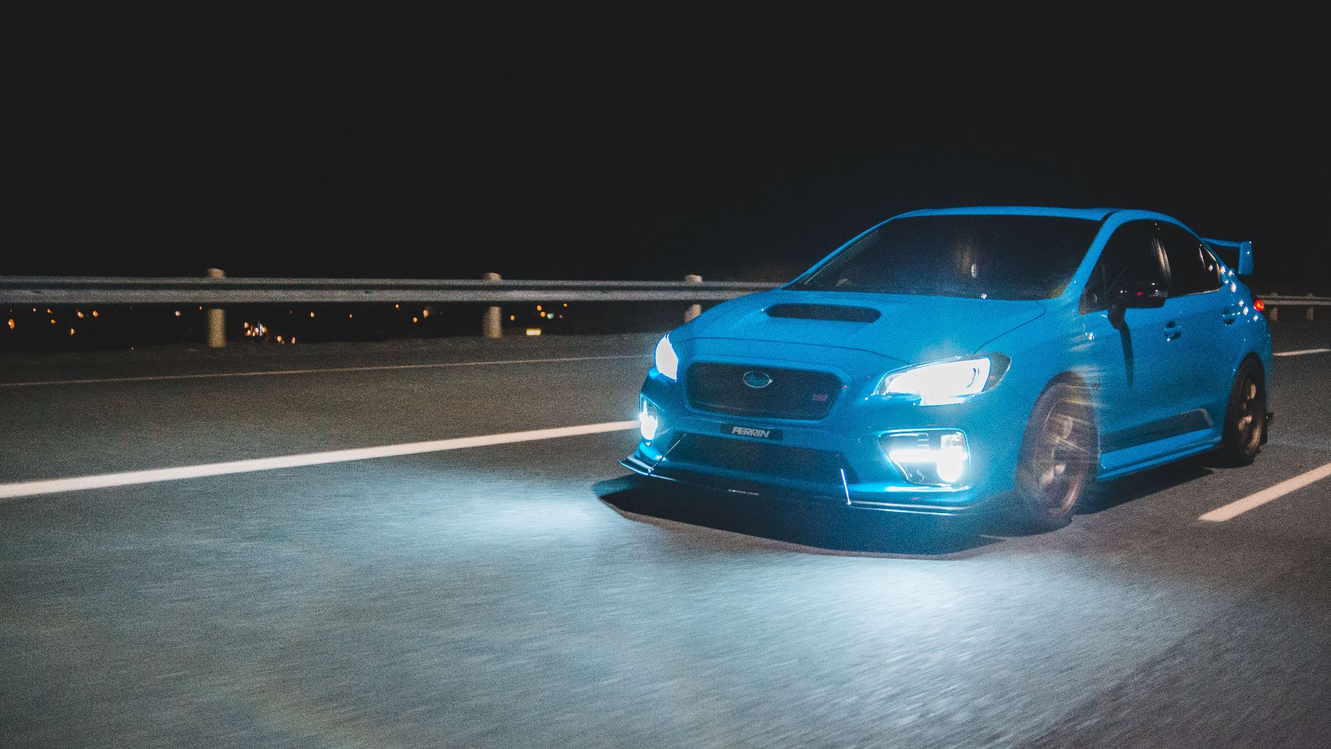 New expensive automobile with luminous headlights riding on asphalt road at dark night