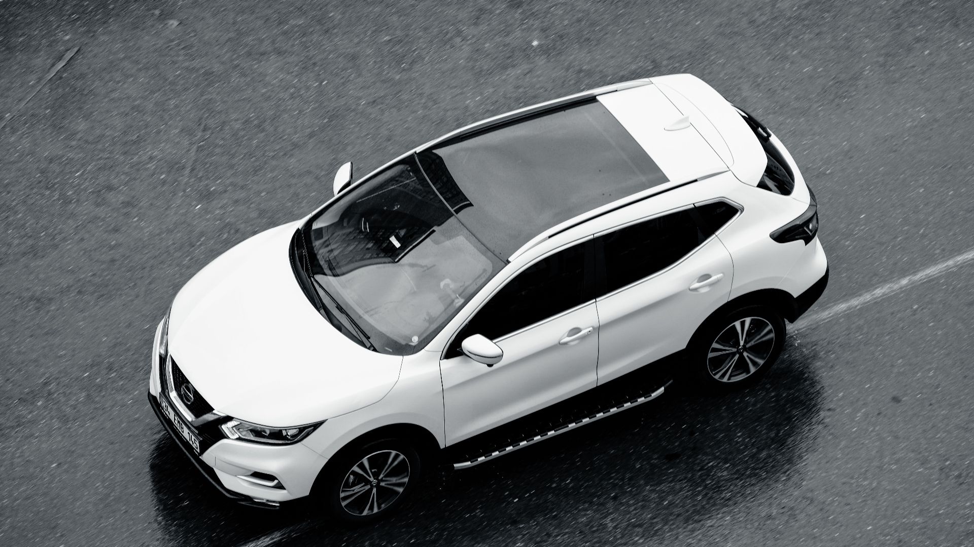 A white SUV is seen from above cruising along the wet streets of Istanbul, Turkey.