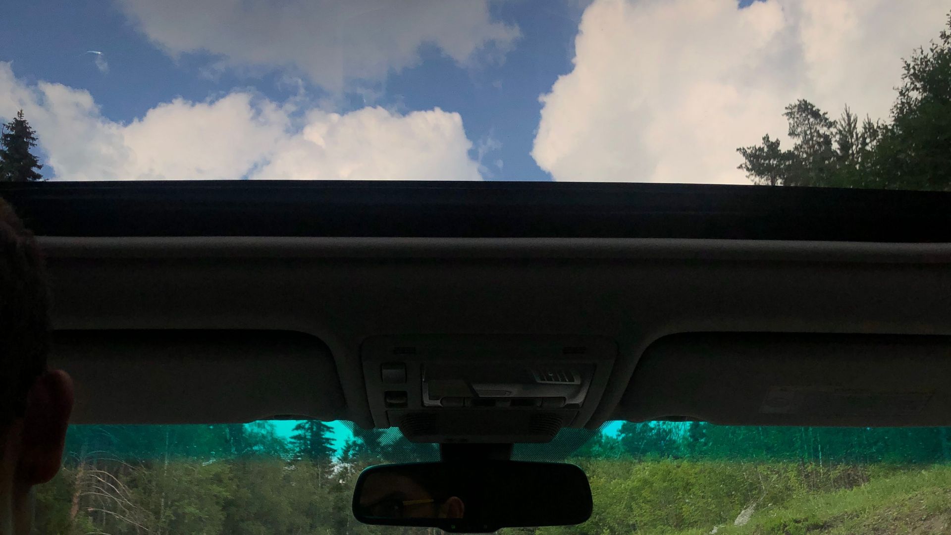 Inside view of a car during a scenic drive through the Russian countryside under a clear sky.