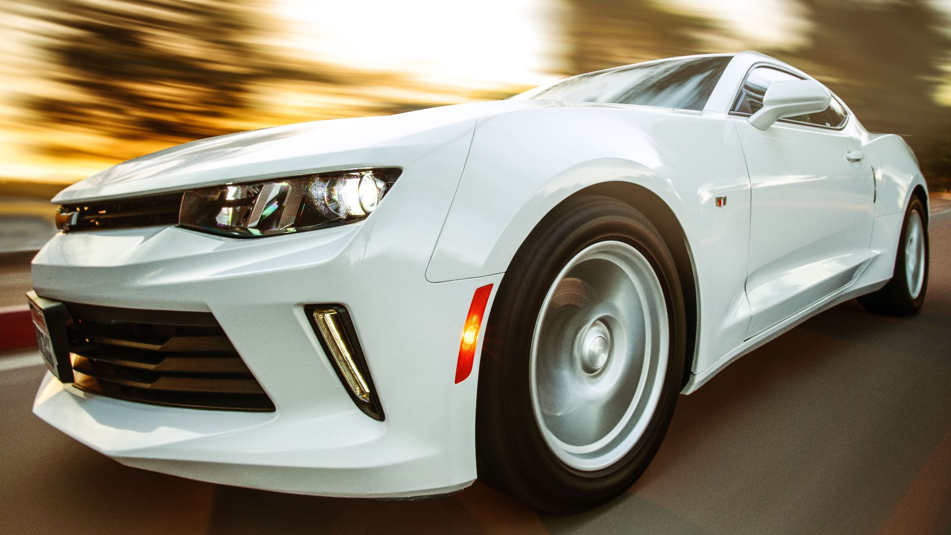 A white sportscar in motion showcasing speed and style on an open road.