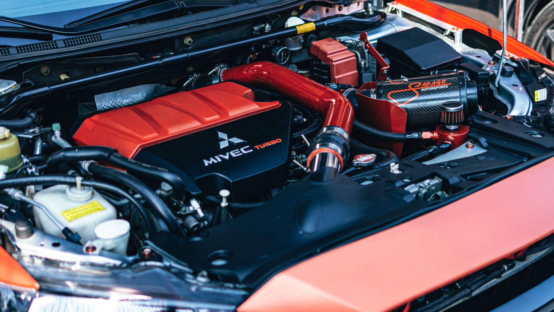Detailed close-up of a high-performance car engine with red accents under the hood.
