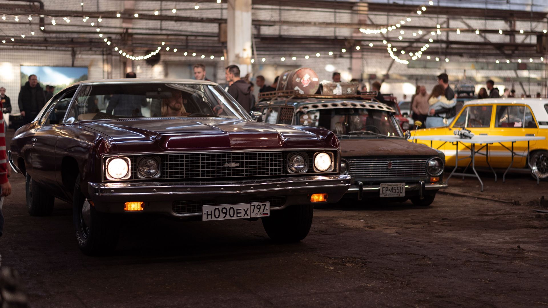 Explore a vintage automotive display featuring classic cars at an indoor exhibition.