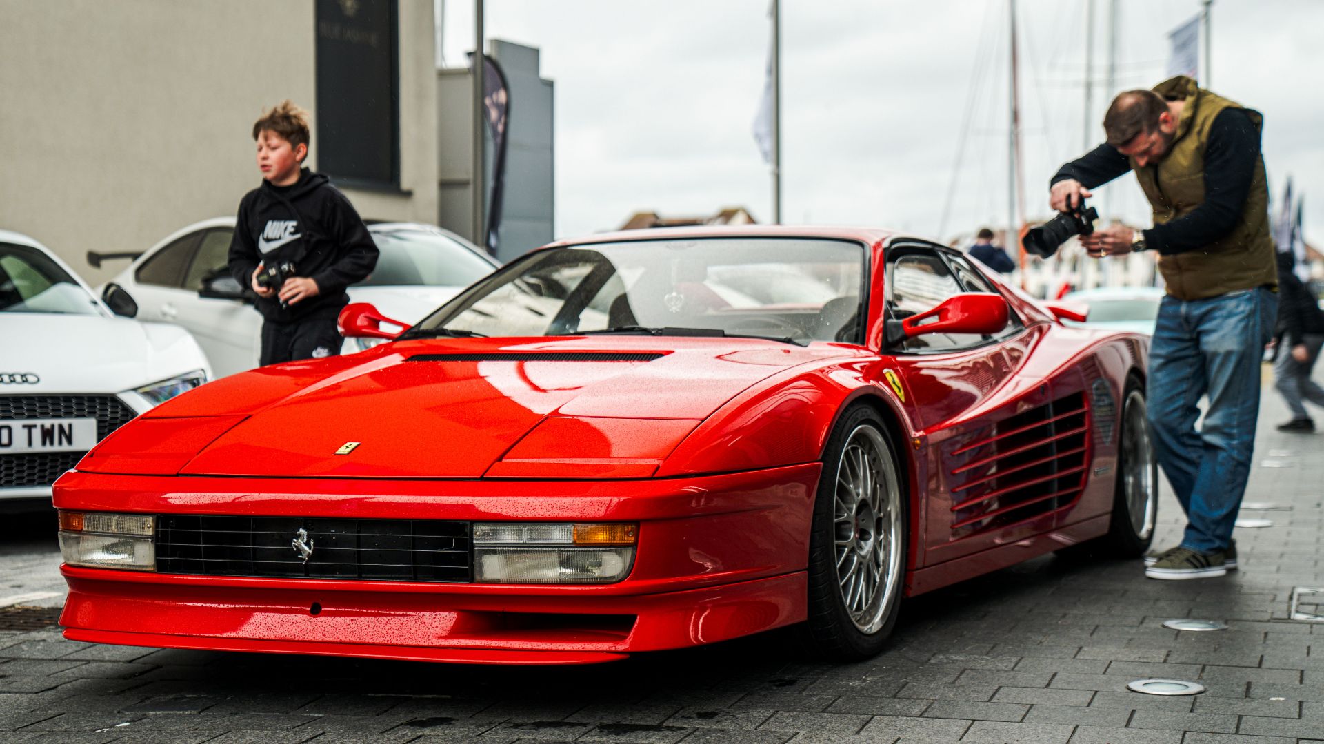 Vibrant red Ferrari Testarossa captured in a bustling street in Southampton, England.