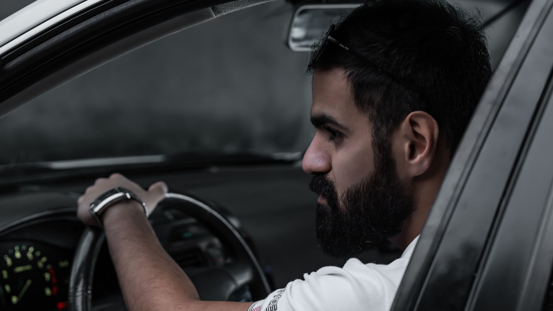 Side view of a man driving a car, concentrating on the road.