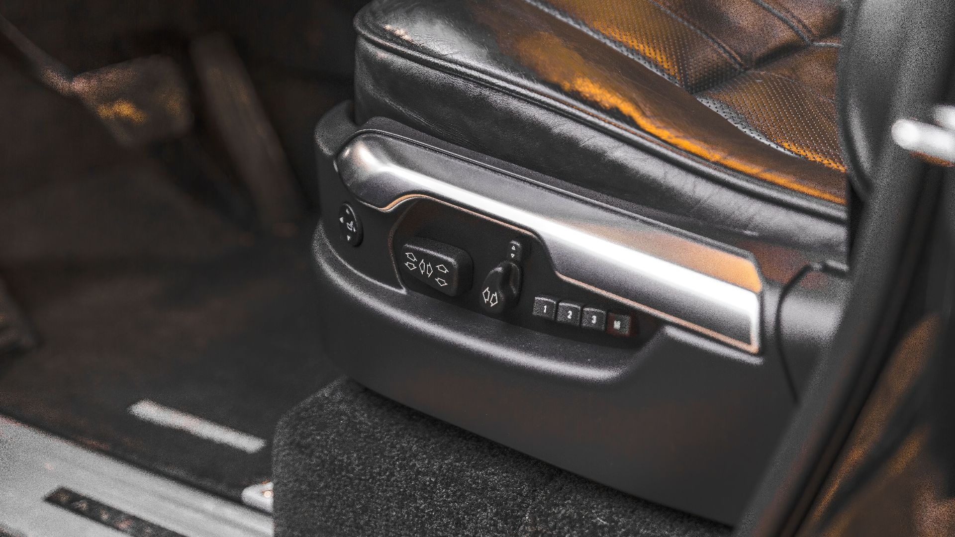 Close-up of a luxury car seat with electric adjustment controls in an SUV interior.