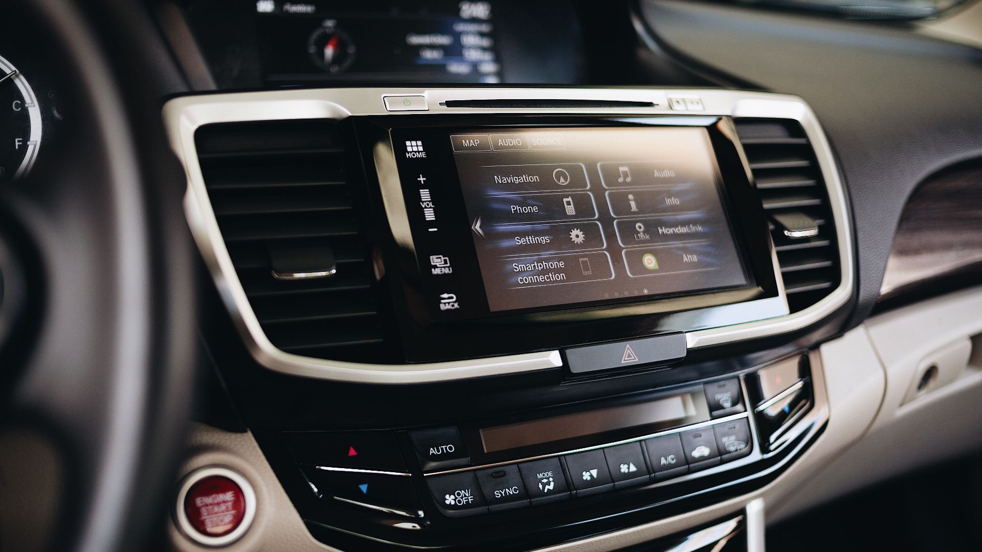 Close-up view of a modern car's infotainment display showing navigation and smartphone settings.