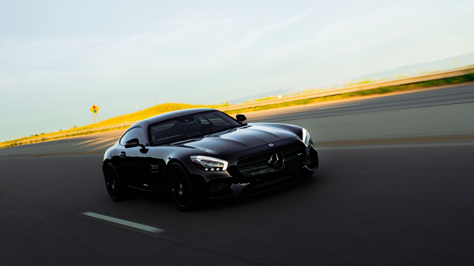 High-performance black sports car speeding down an open highway, showcasing luxury and elegance.
