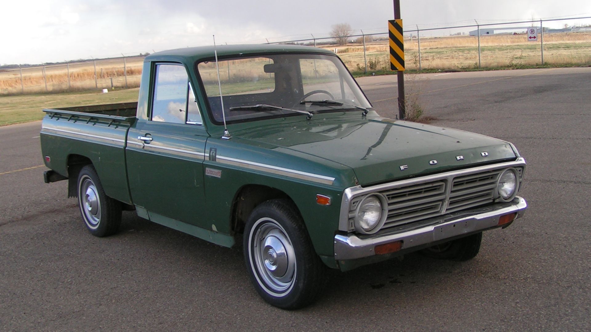A green 1976 Ford Courier pickup truck.