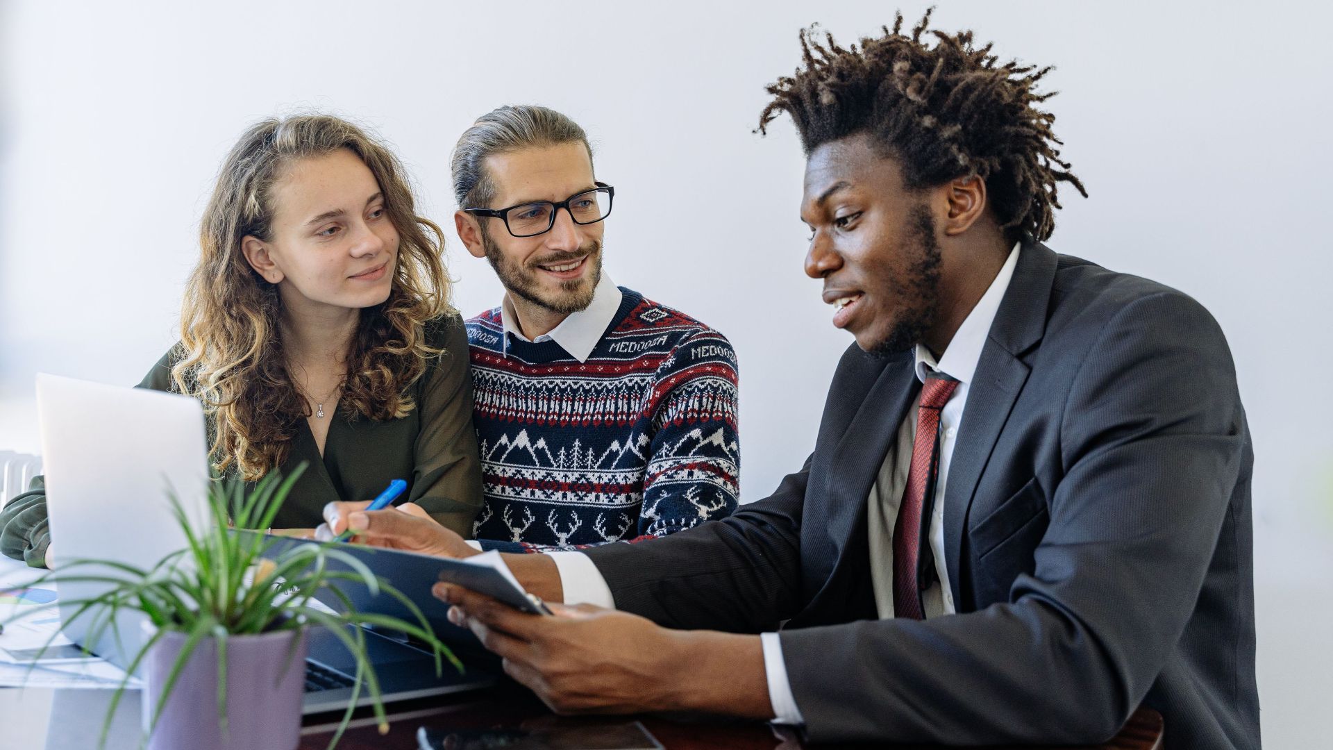 A diverse group of professionals collaborating in an office meeting, showcasing teamwork and partnership.