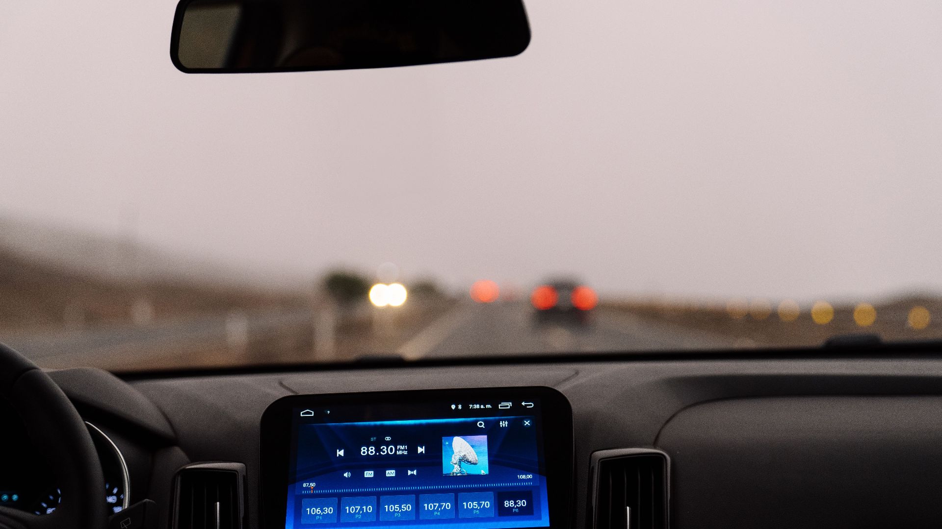 Interior view of a car dashboard on an open road during the day. Perfect for travel-themed projects.