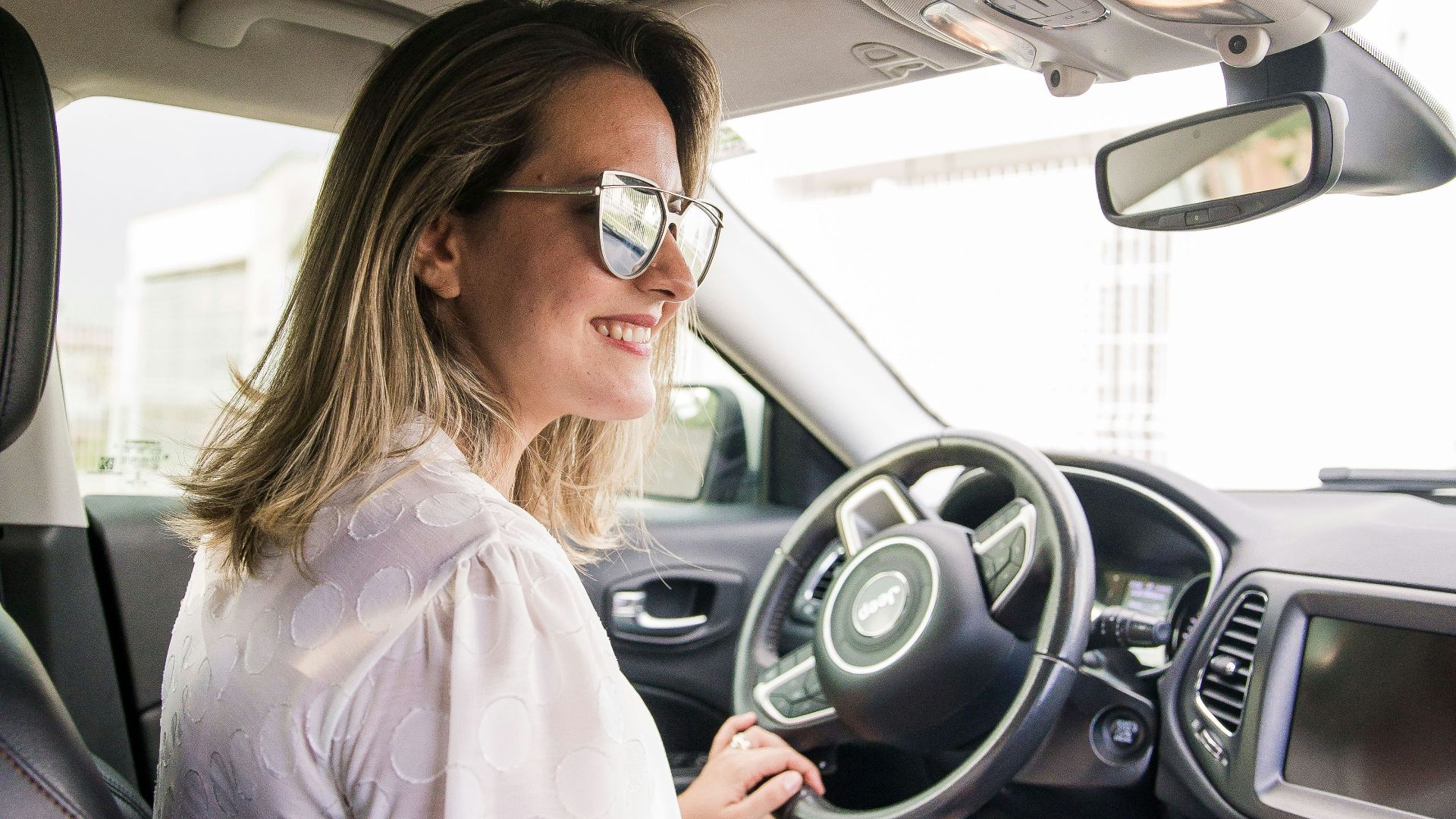 woman in white long sleeve shirt driving car