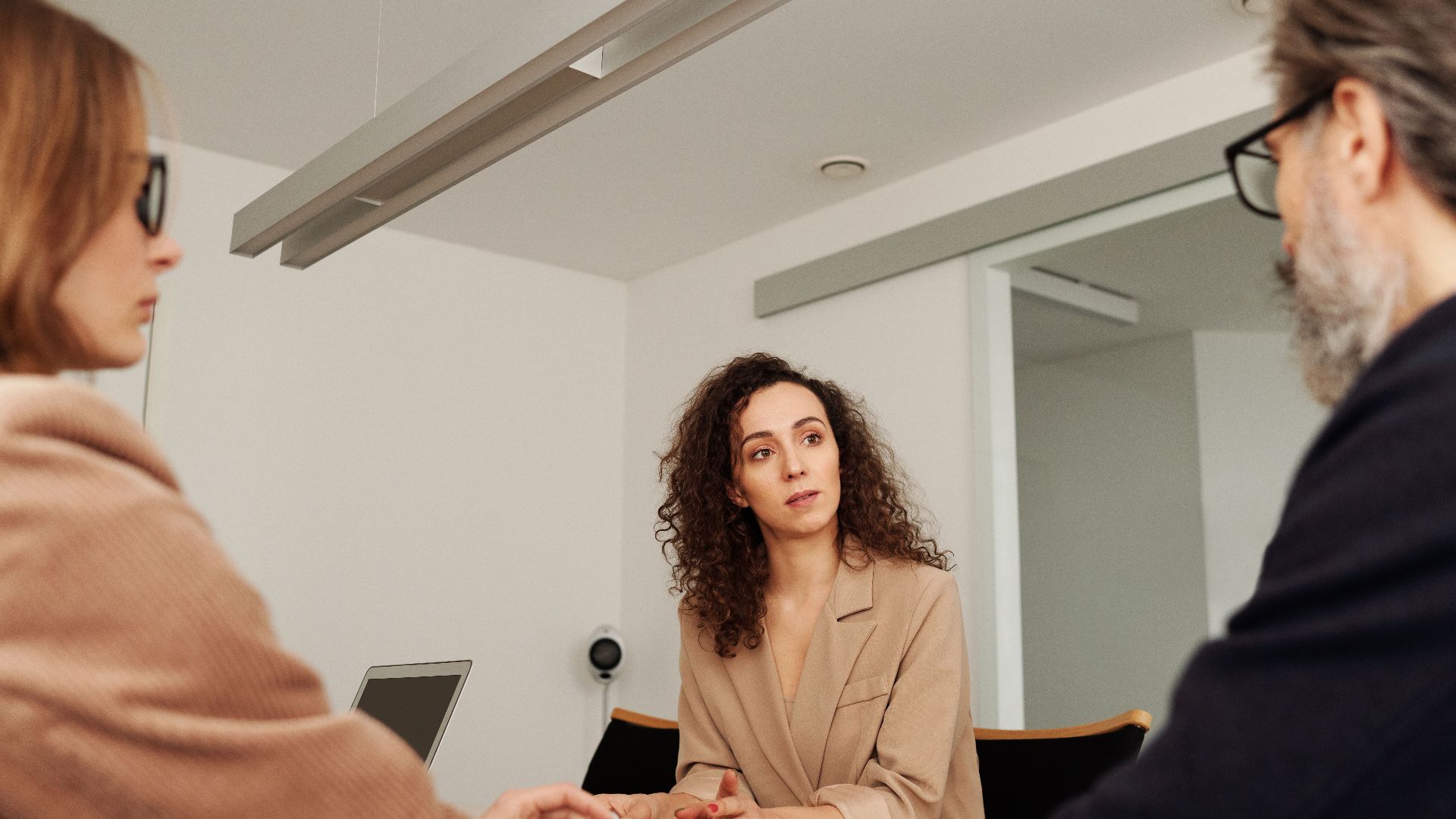 Professionals engage in a focused discussion during a business meeting in a modern office setting.