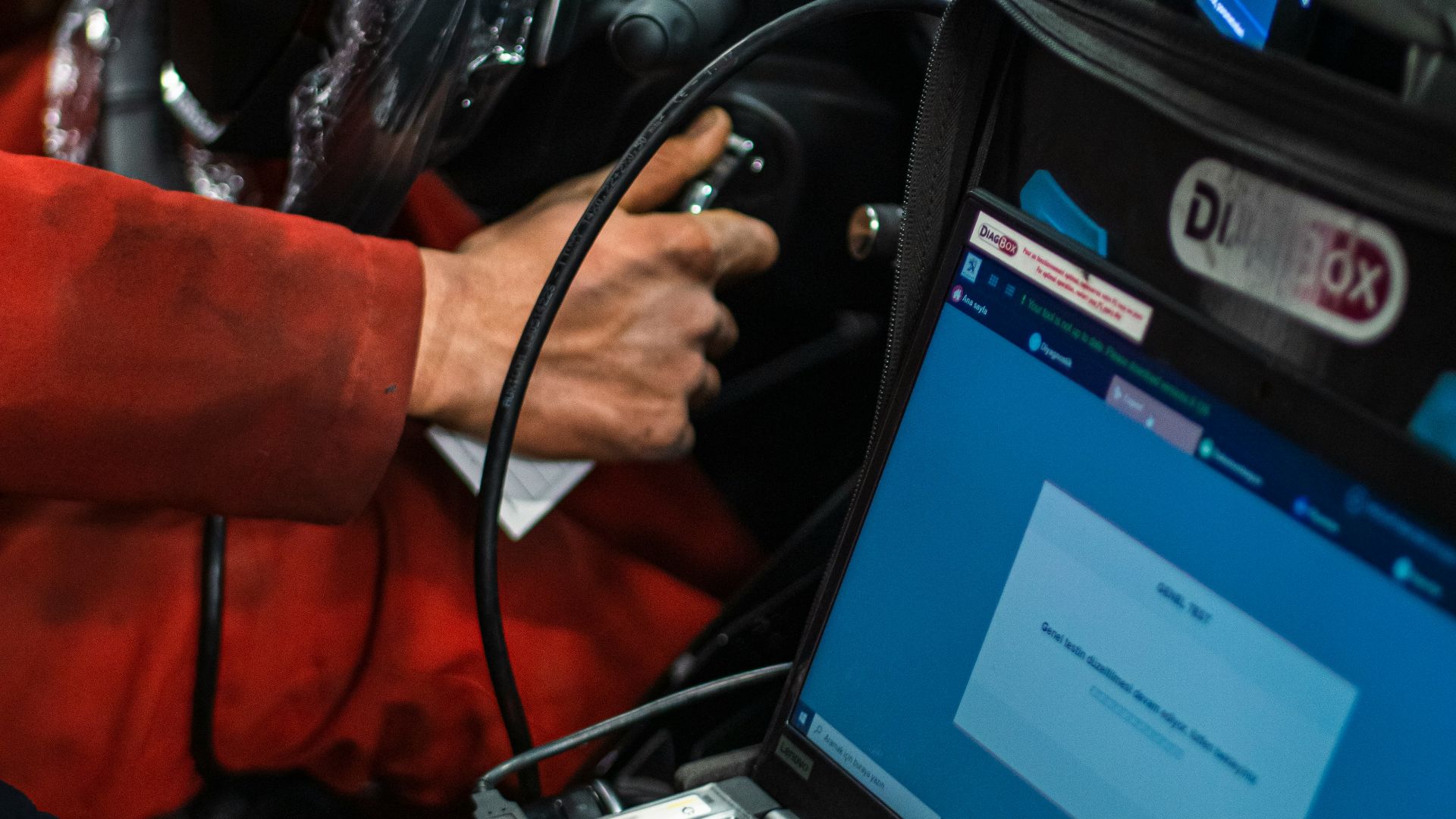 A man sitting in a car using a laptop computer