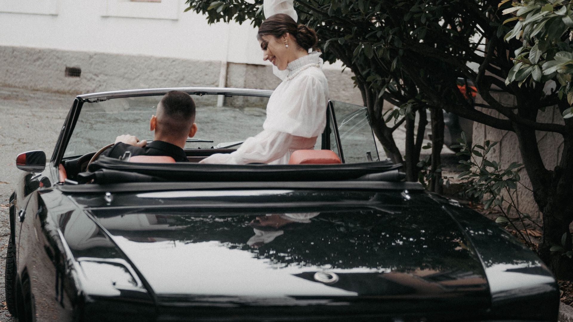 A couple in a classic convertible car enjoying a scenic drive in Livadiya.