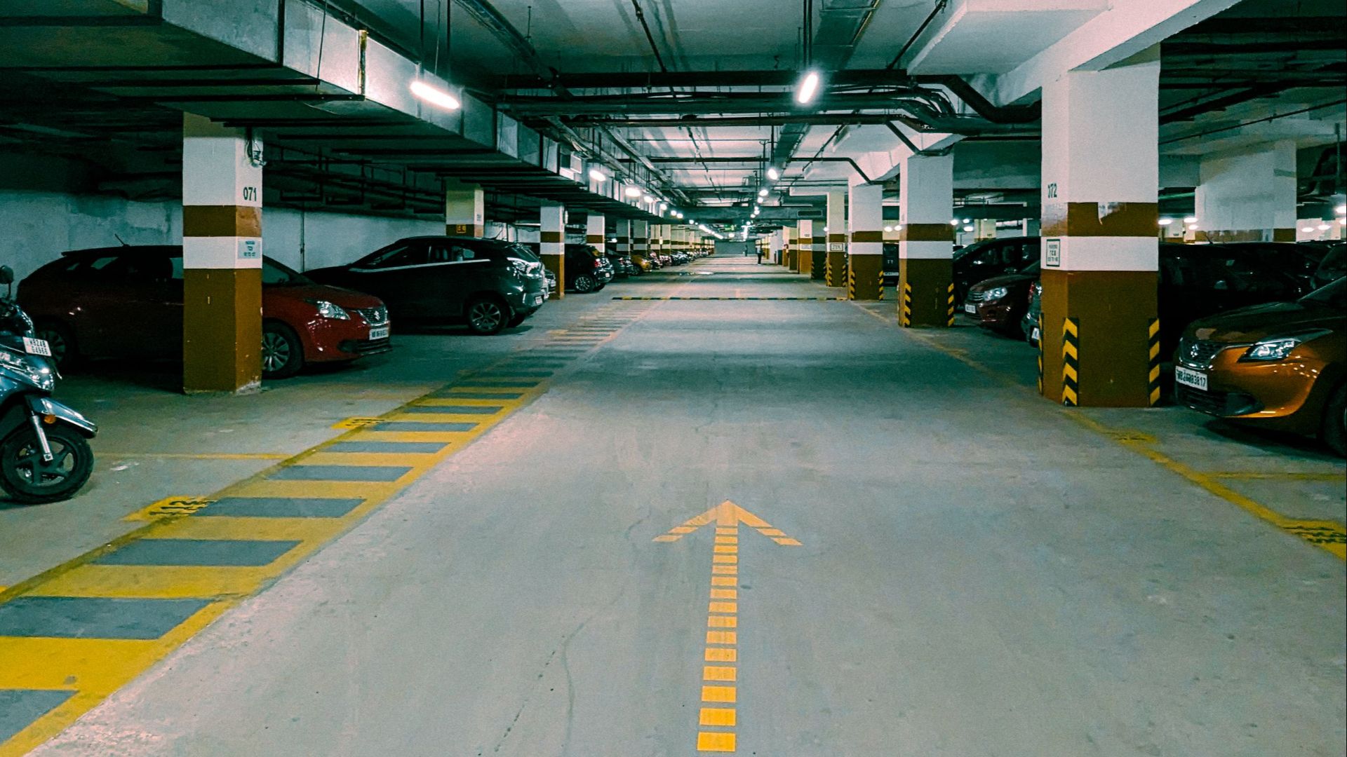 A view of an underground parking garage in Candor, India, showcasing symmetry and perspective.