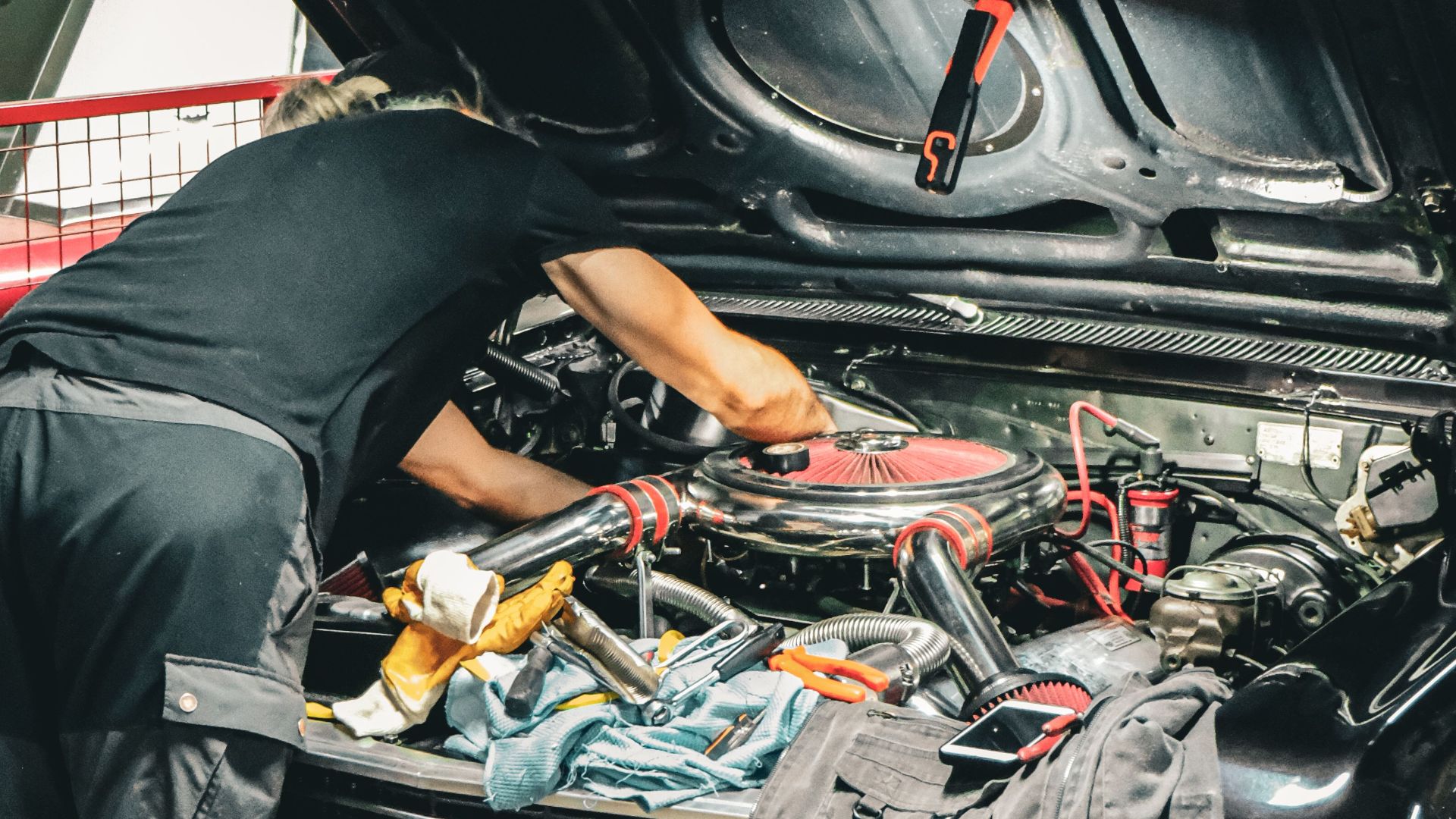 Mechanic repairing classic car engine in an Ankara garage, capturing vintage automotive repair scene.