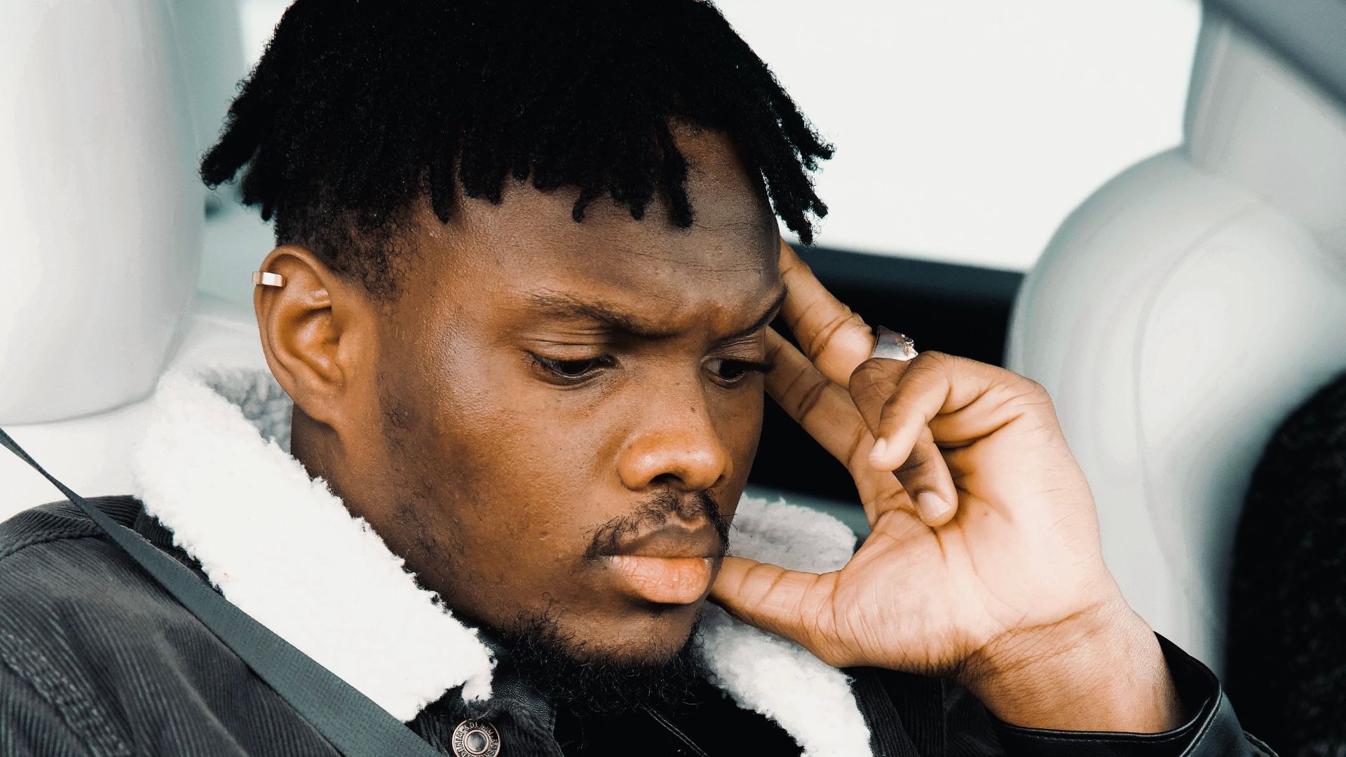Pensive young man in a car seat, deep in thought in Montreal, Canada.