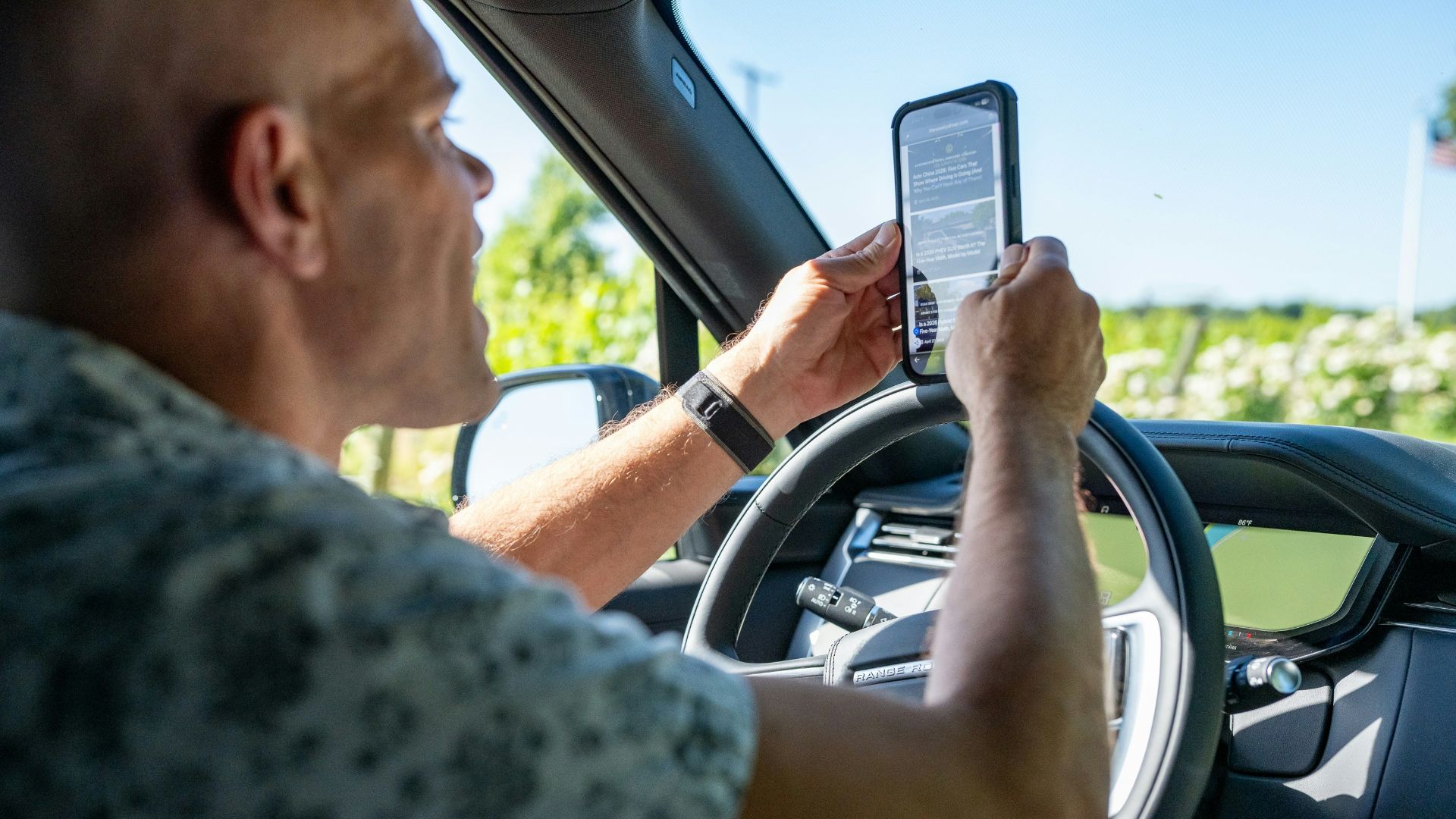 Man holding phone while driving a car
