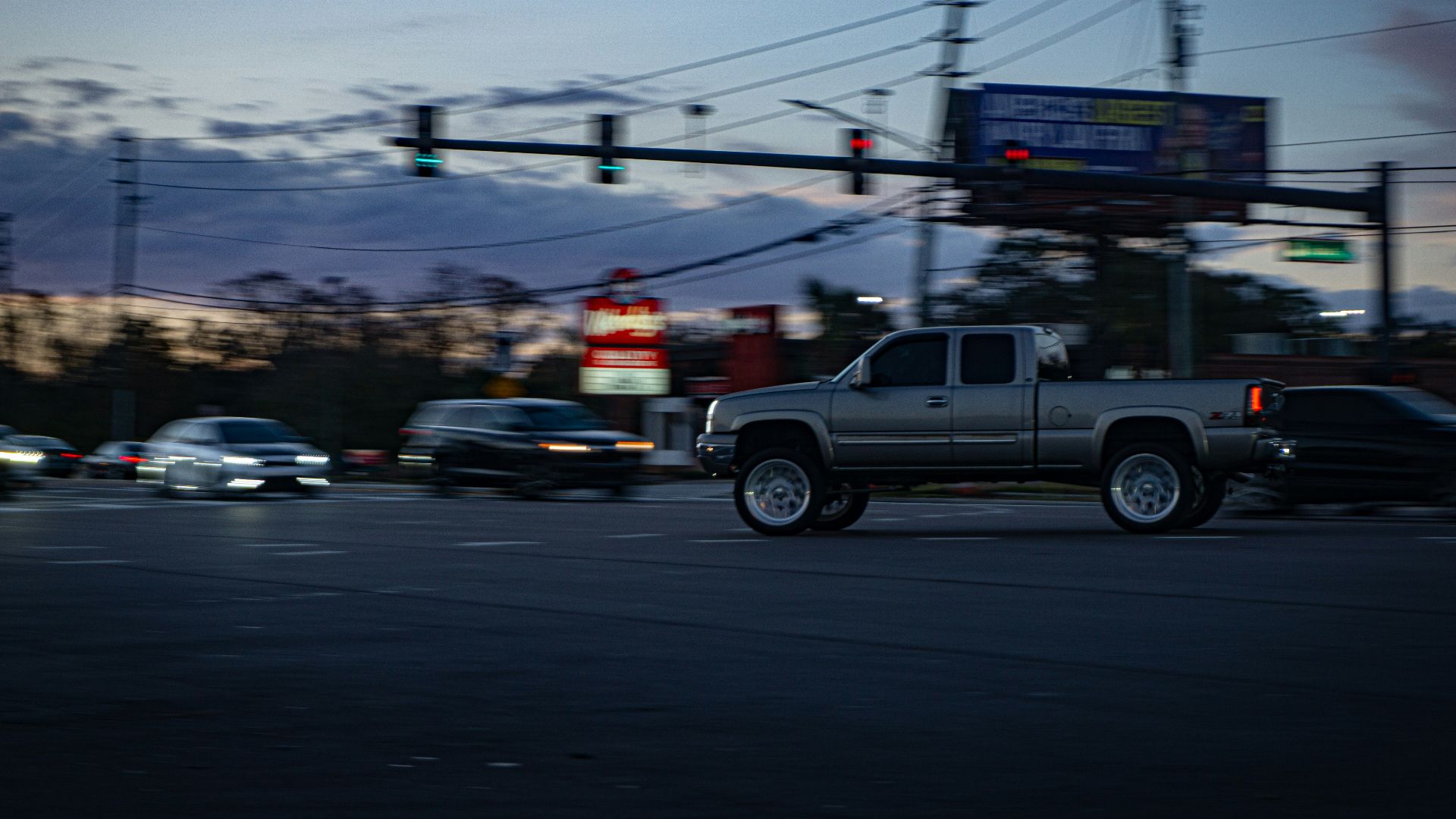 Pickup truck driving through city intersection at dusk