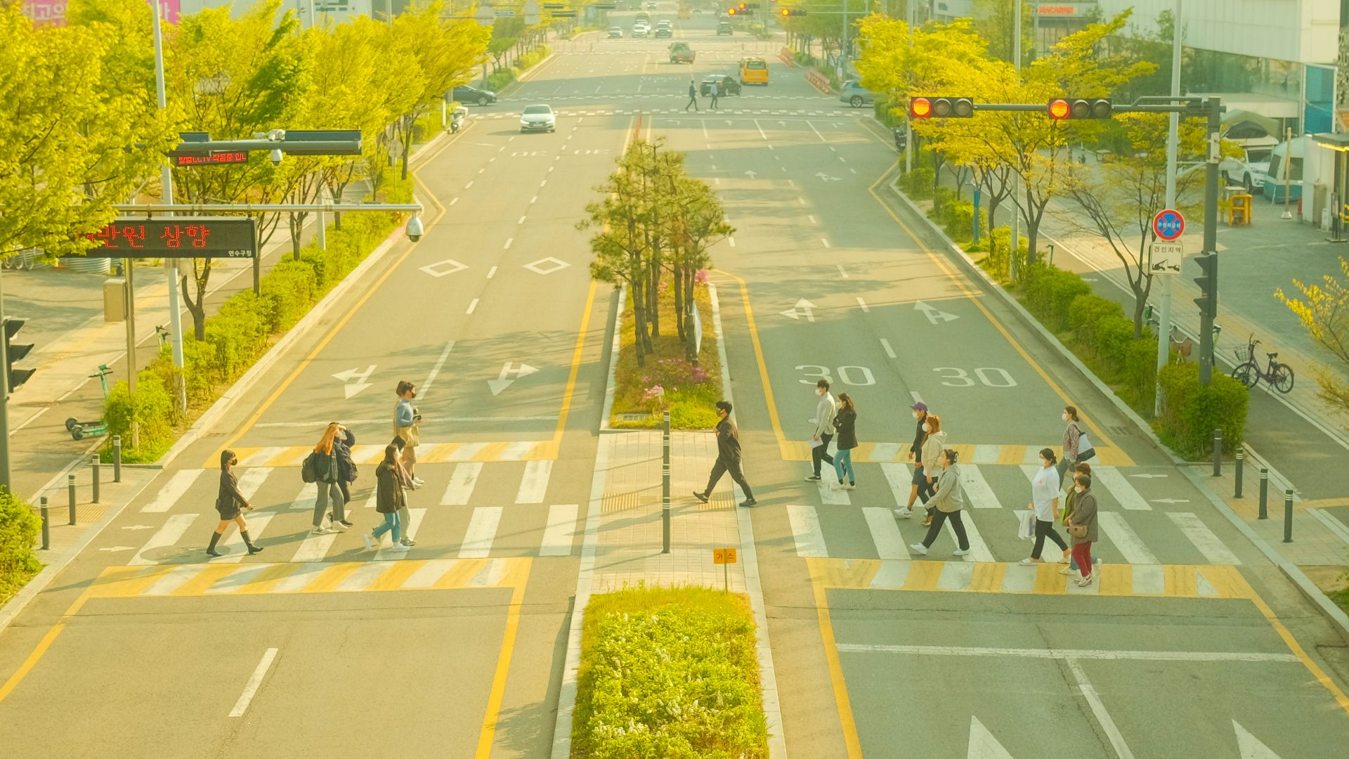 a group of people walking across a street